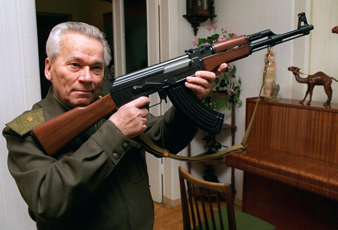 ميخائيل كلاشنكوف الأب يحمل بندقية "AK-47"