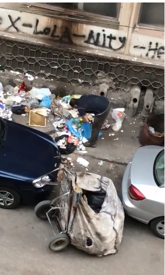 عمال القمامة يقومون بفرزها فى الشارع