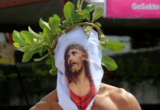 أحد الأشخاص يضع صورة المسيح على وجهه
