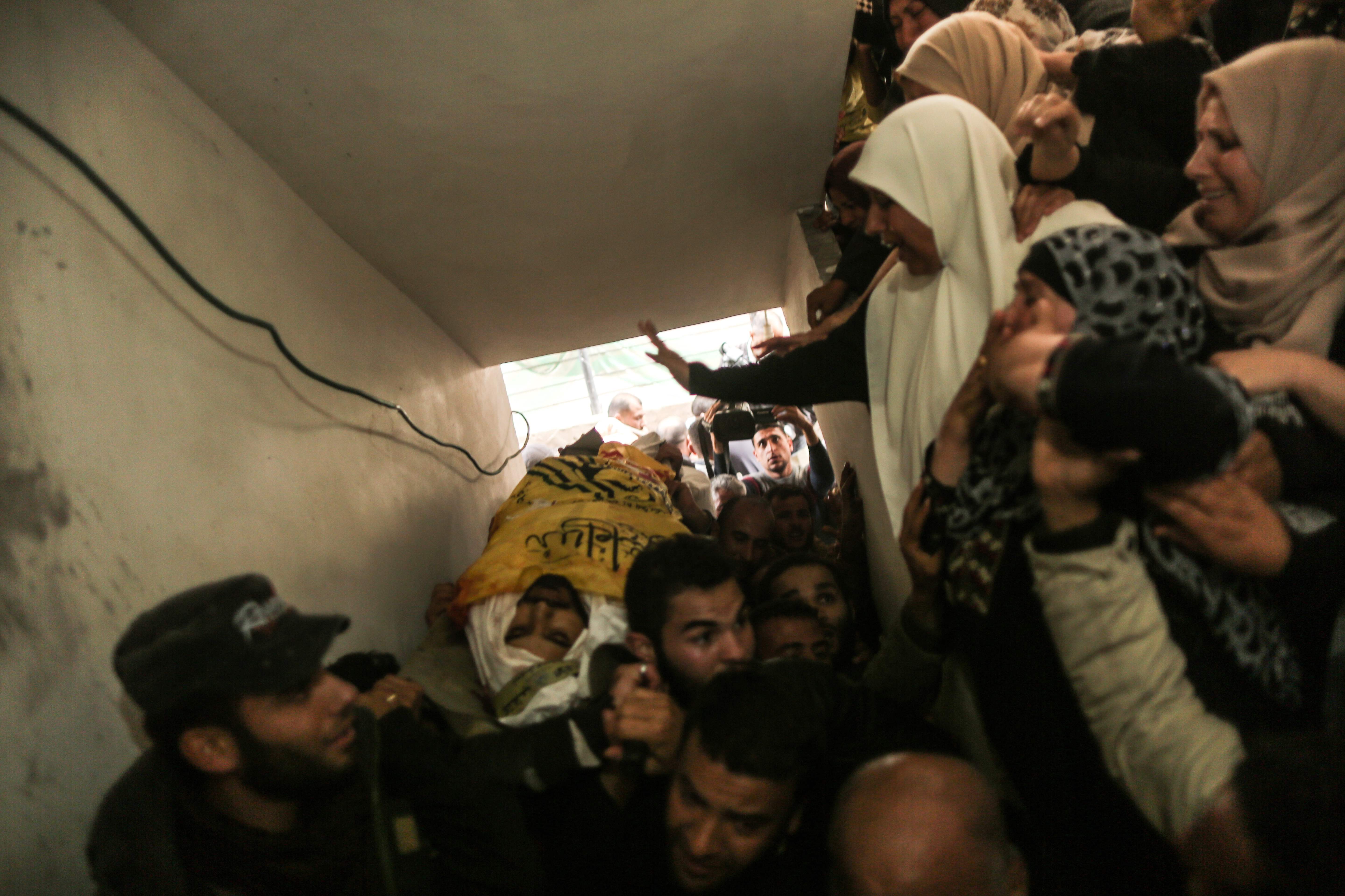 فلسطينيون يحملون جثمان شهيد