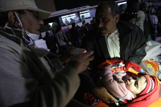 رجل  سورى يحمل طفلته لمغادرة الغوطة الشرقية