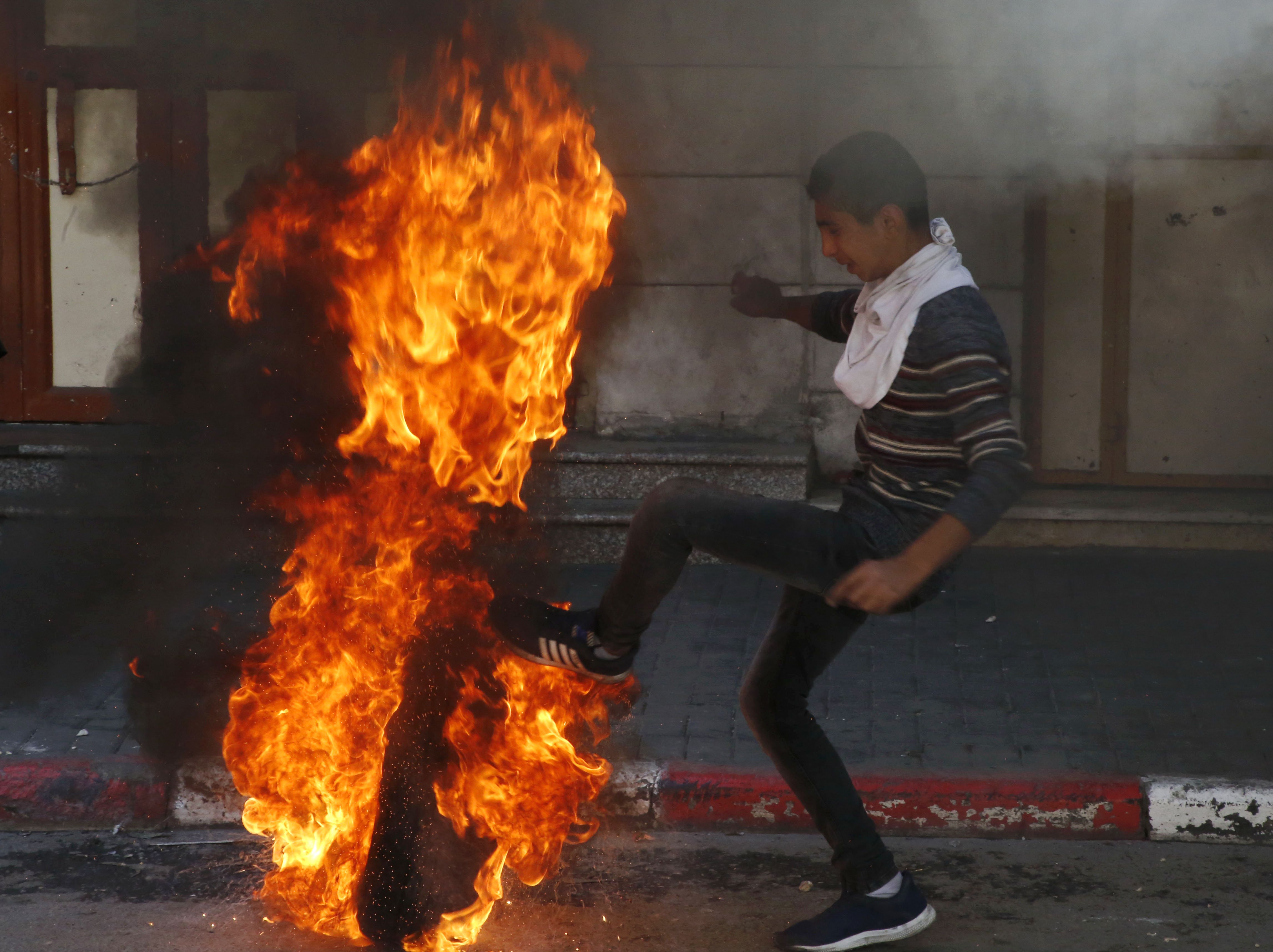 فلسطينى يشعل النيران فى إطار سيارة