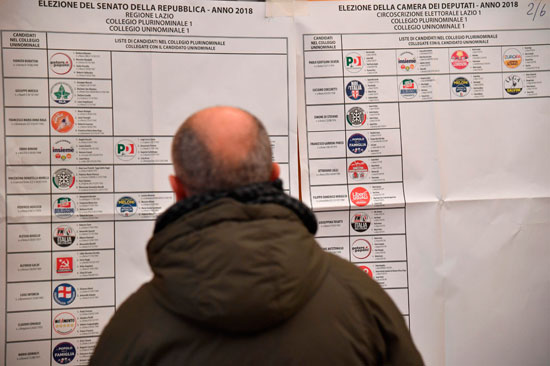 ناخب تطلع على اللوحة الإرشادية للانتخابات فى إيطاليا