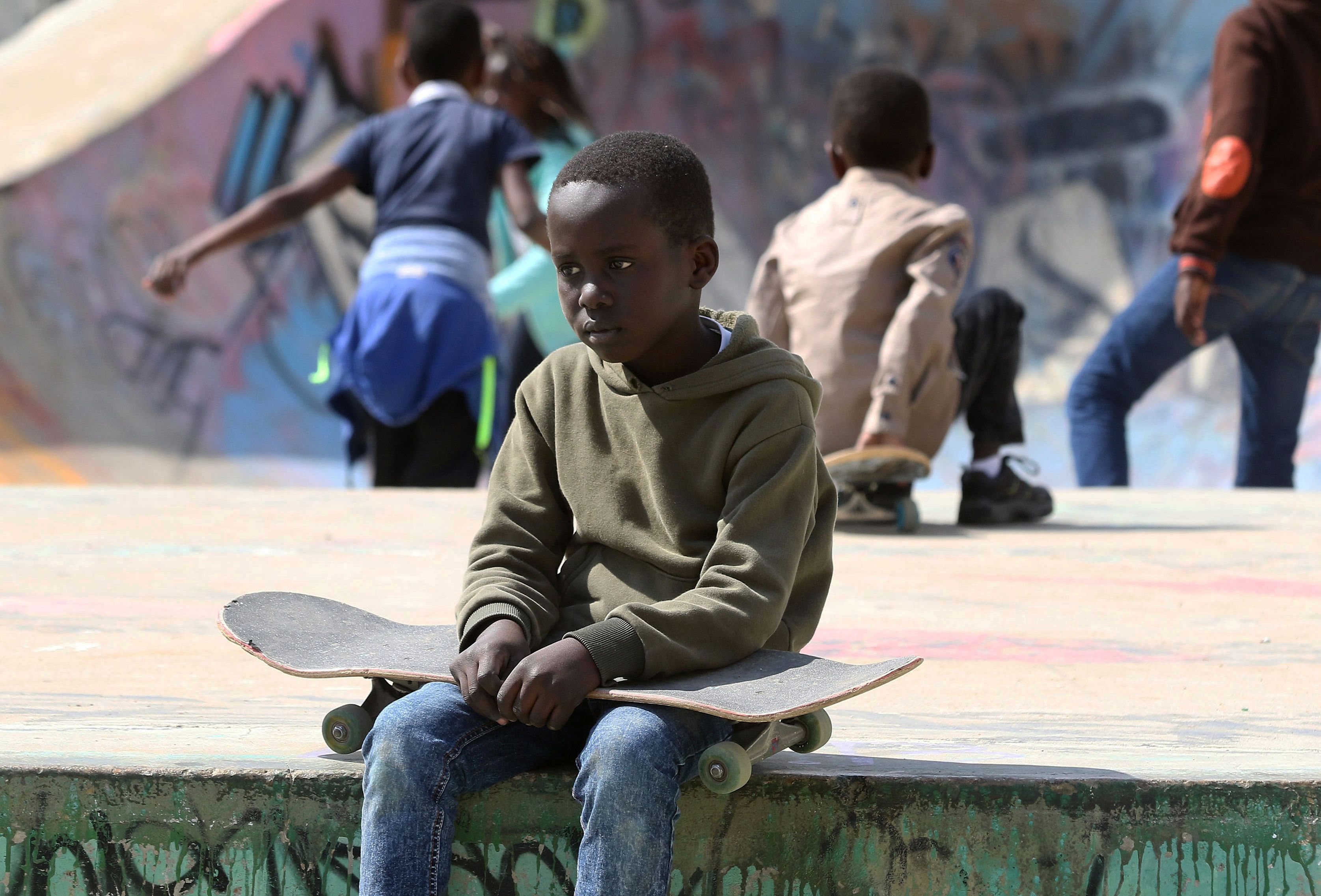 طفل لاجئ يجلس فى حديقة هيلز سكي