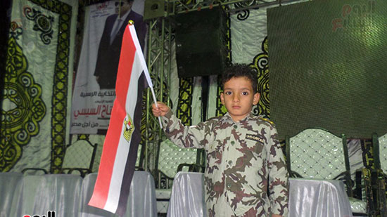 طفل يرتدى الزى العسكرى ويحمل علم مصر