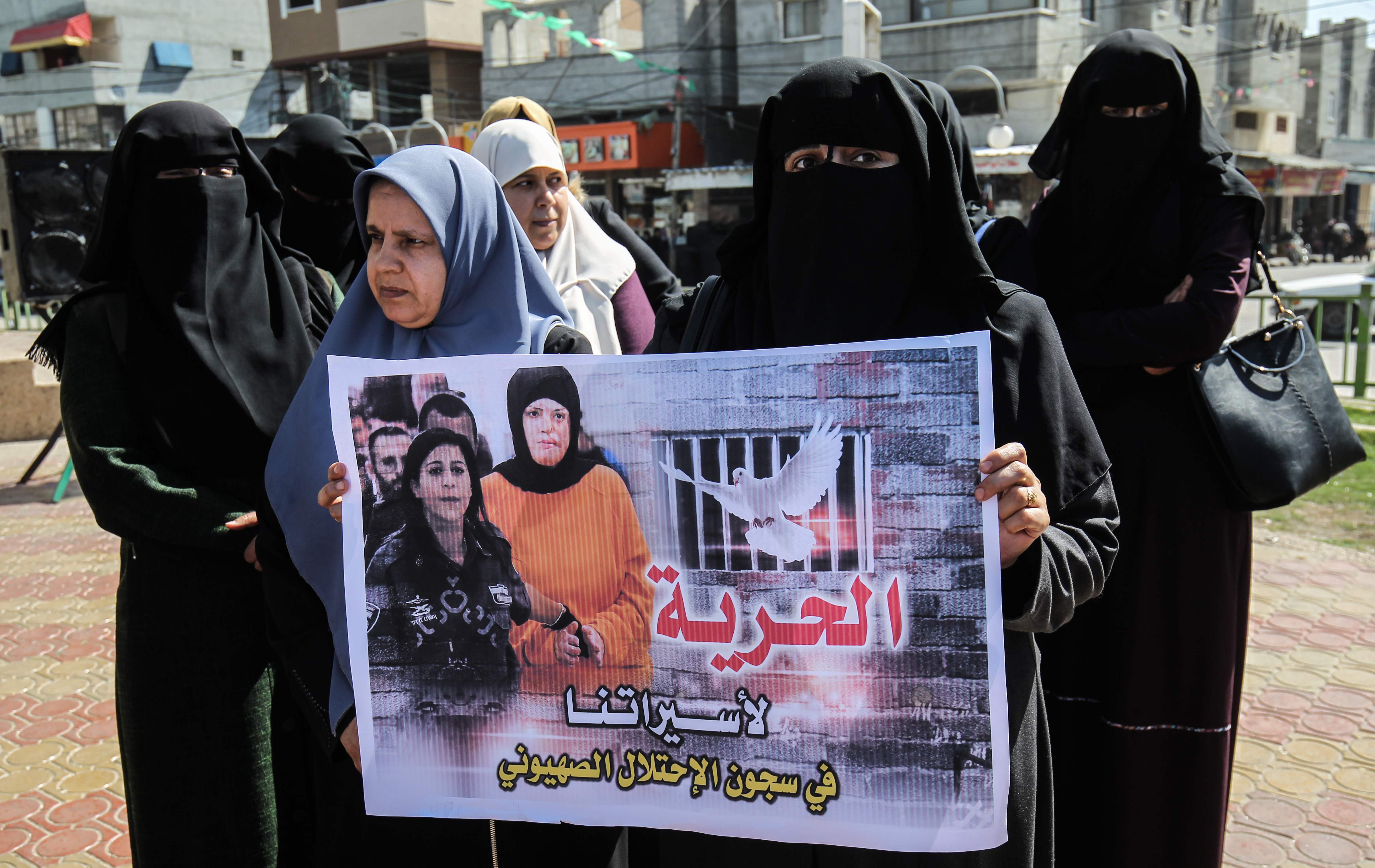 متظاهرات برفعن صورا للمعتقلات فى سجون الاحتلال