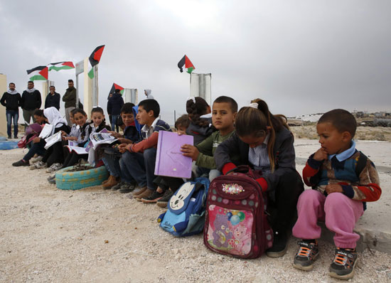  الأطفال يجلسون على الحدود ومعهم أدواتهم 