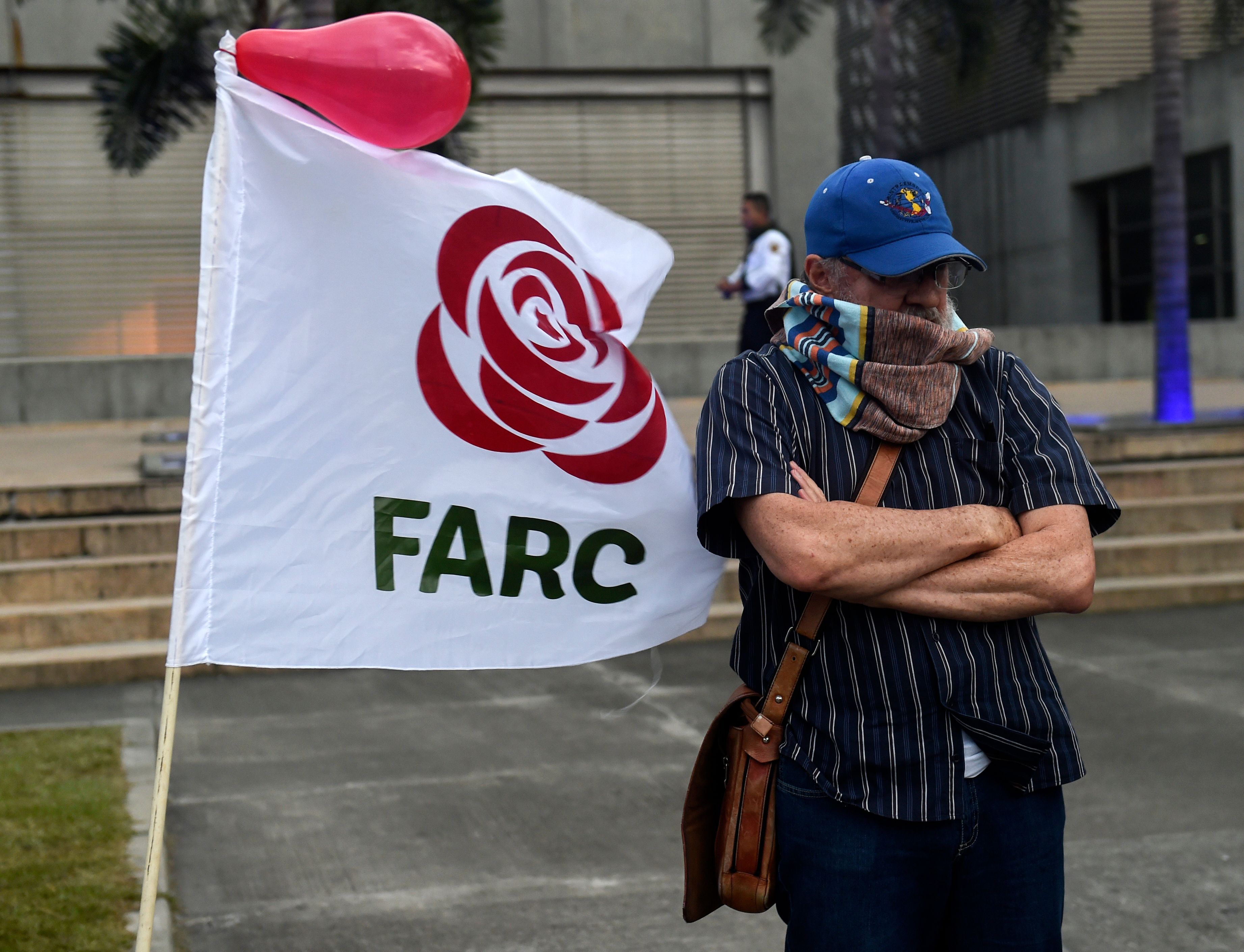 متظاهر فى كولومبيا يقف جنب شارة حركة فارك