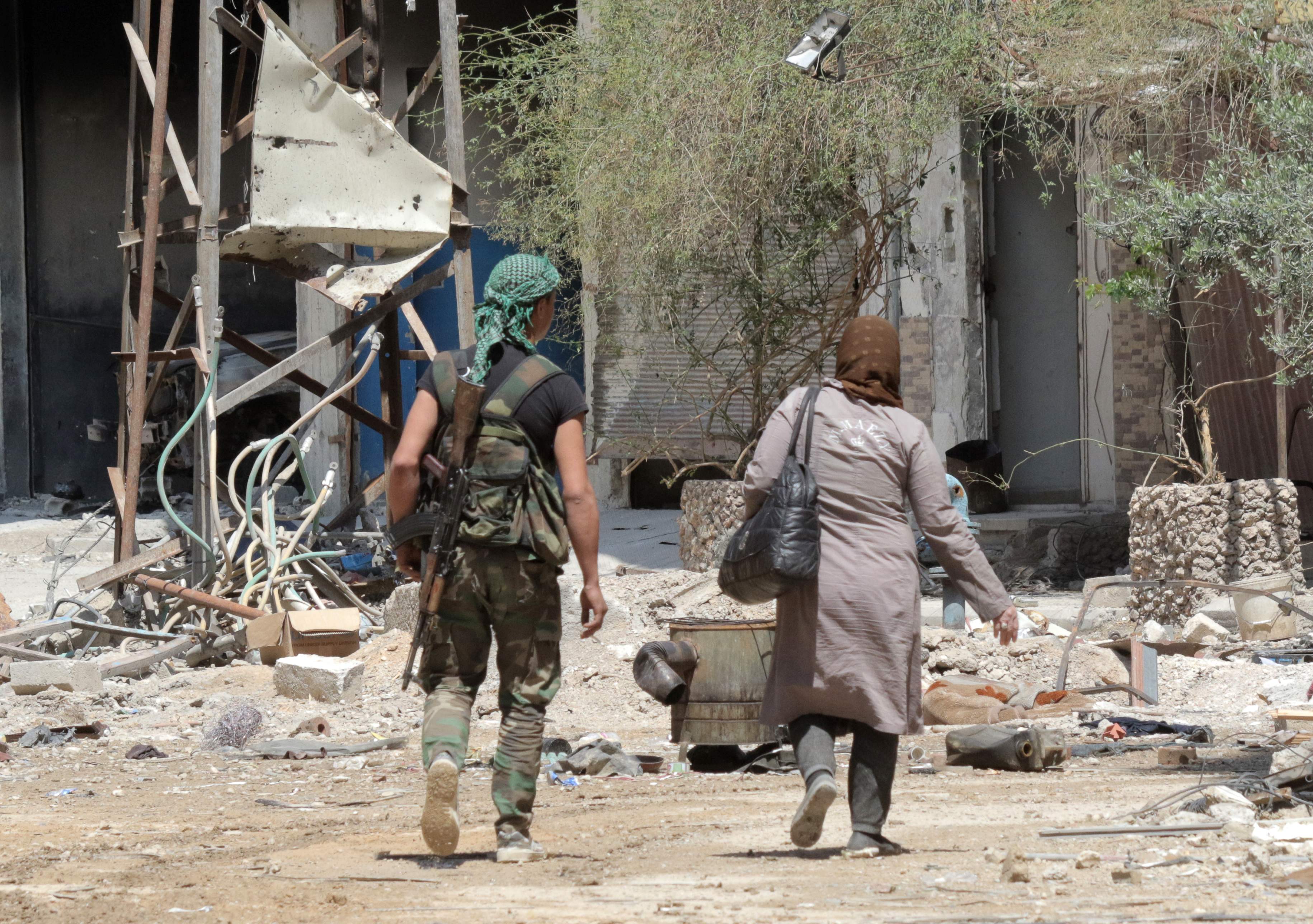 امرأه سوريه تبحث عن منزلها وسط الدمار 