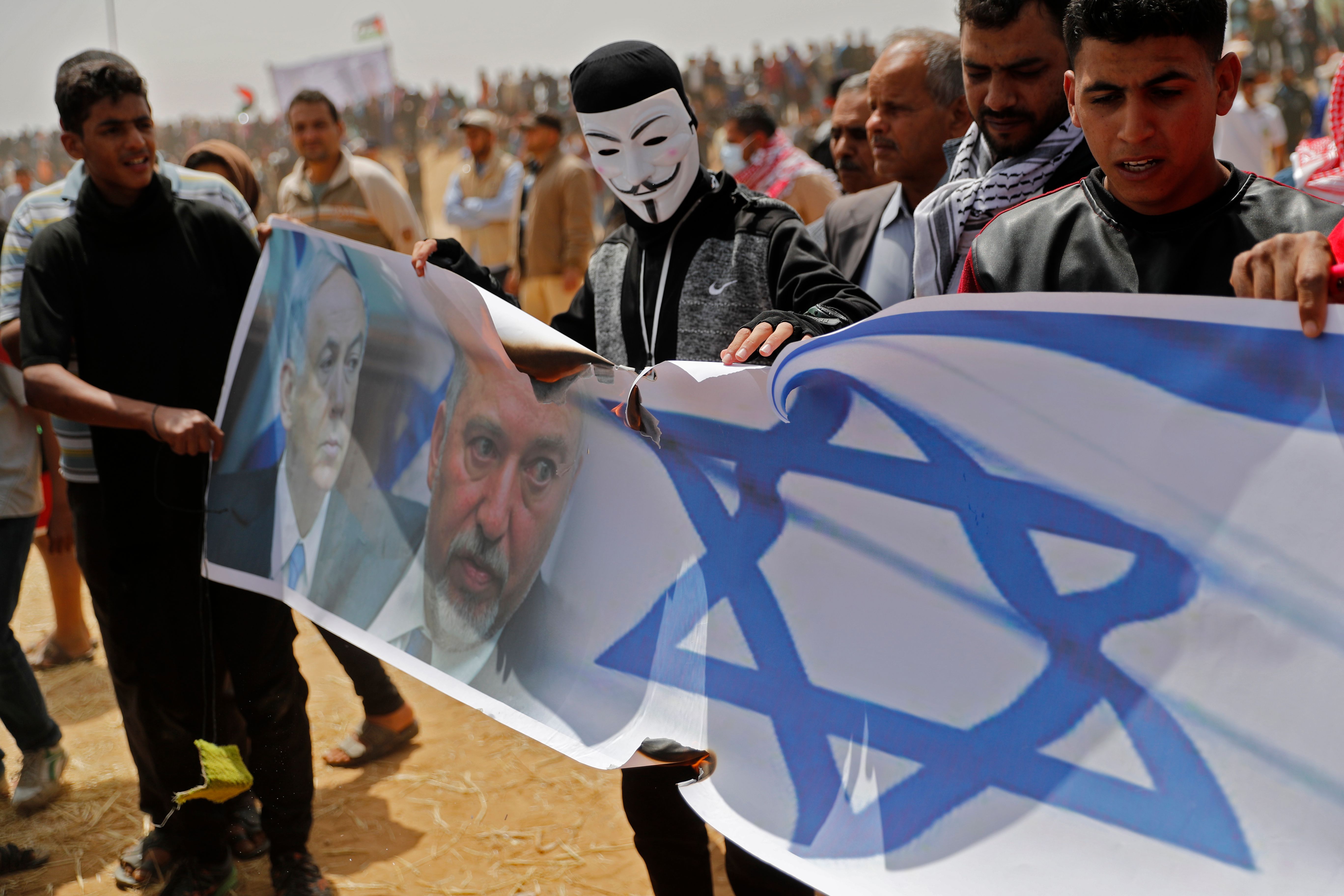 فلسطينيون يحملون أعلام إسرائيل تنديدا بالاحتلال