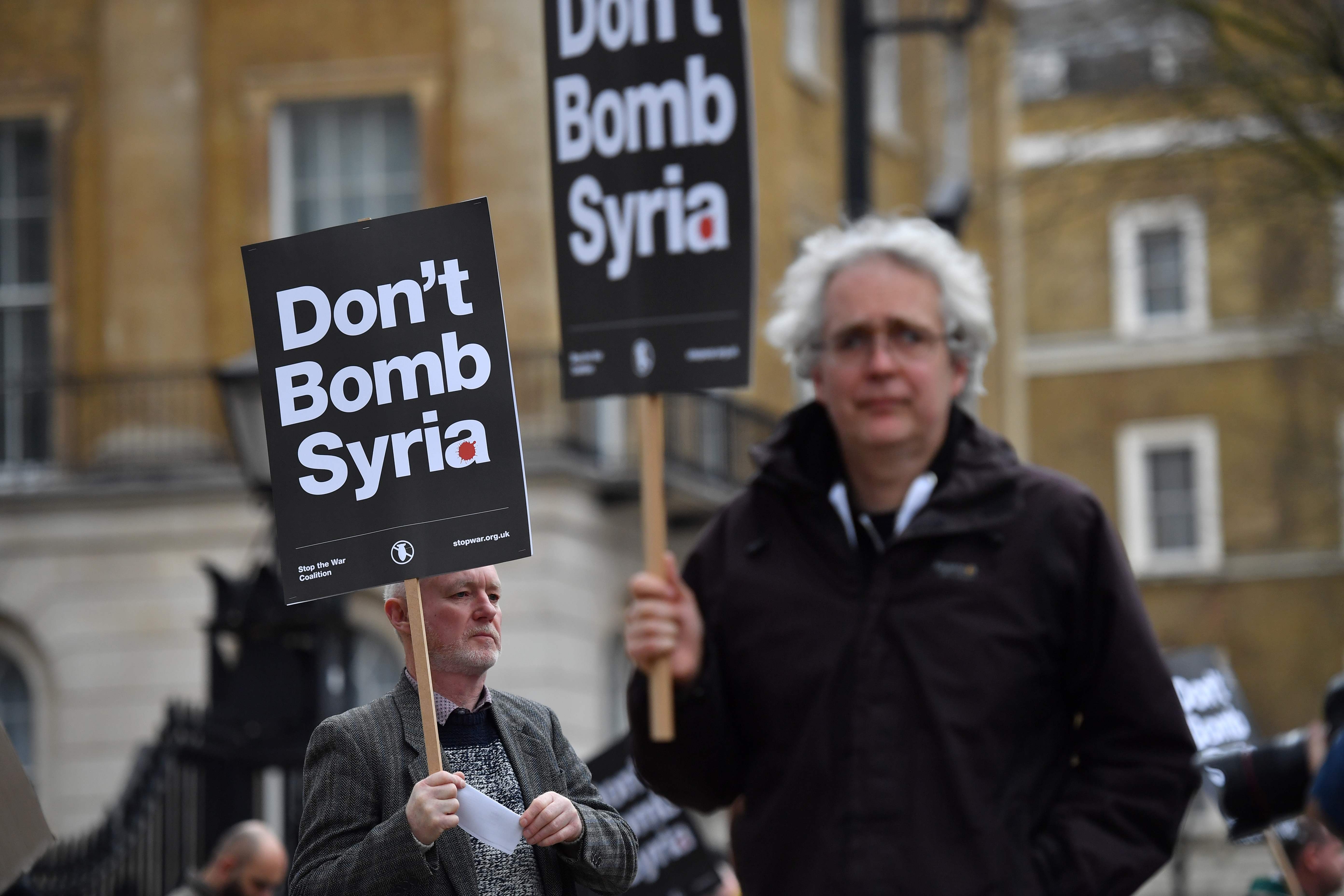 مواطن بريطانيا يحمل لافتة ضد الحرب بسوريا