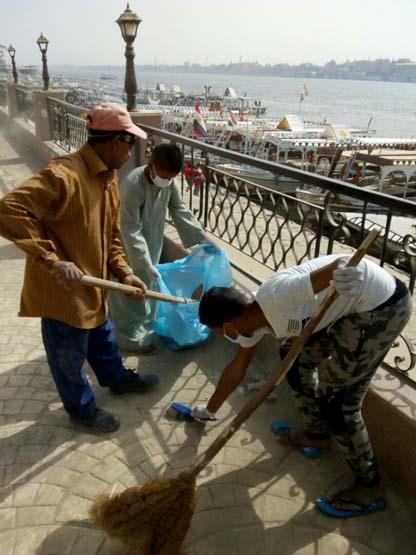 عمال مجالس المدن خلال المشاركة فى تنظيف نهر النيل