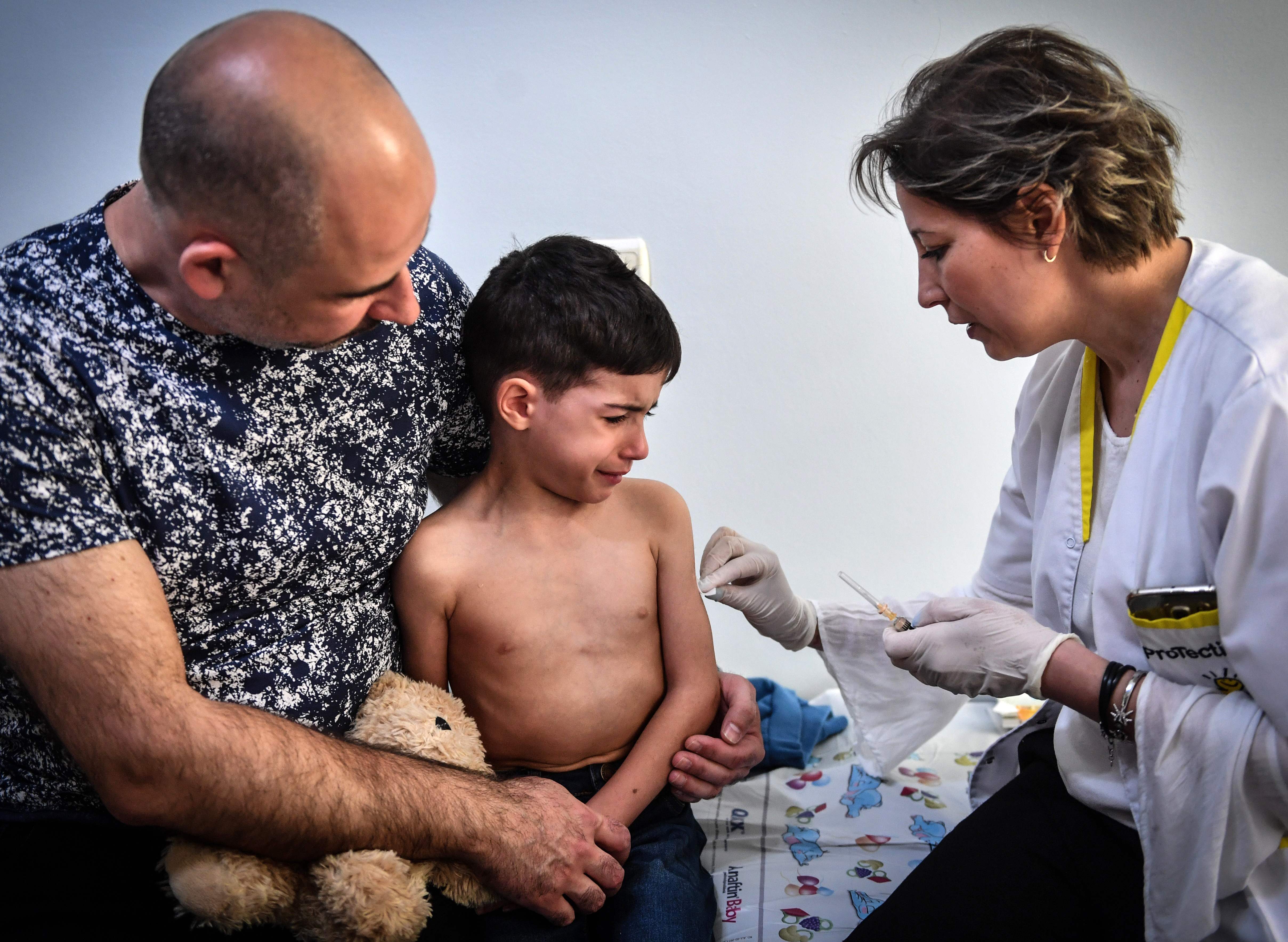 طفل يأخذ حقنة التطعيم