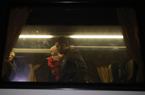 رجل يحمل طفلة داخل الحافلة