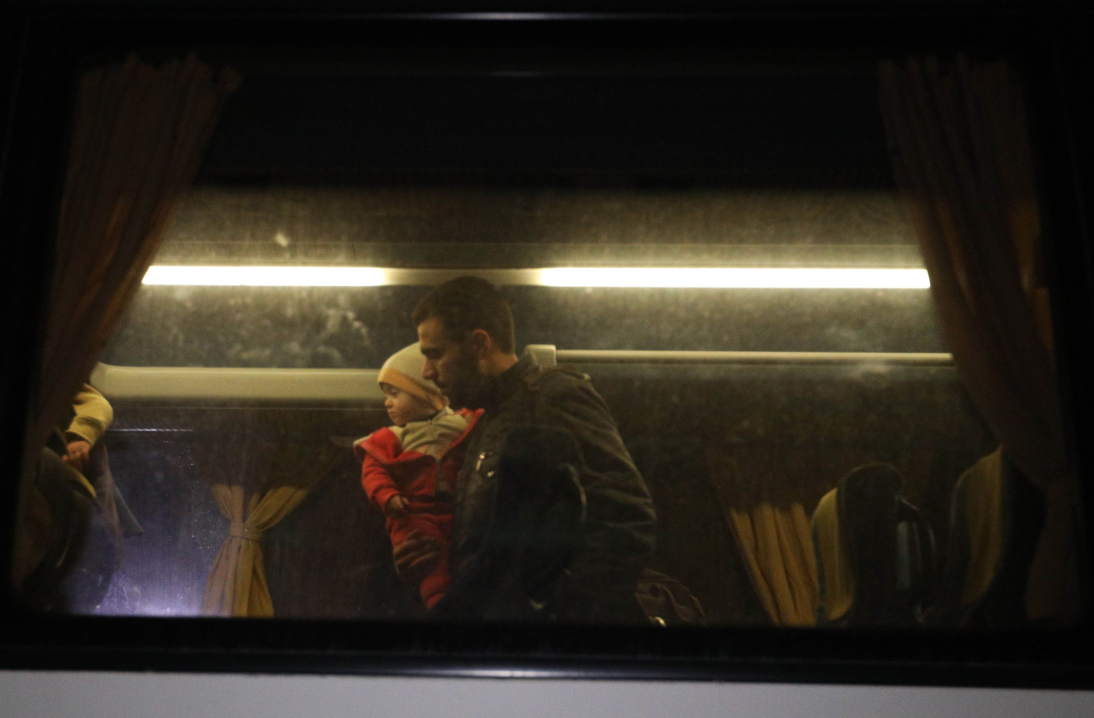 شخص يحمل طفلة داخل الحافلة