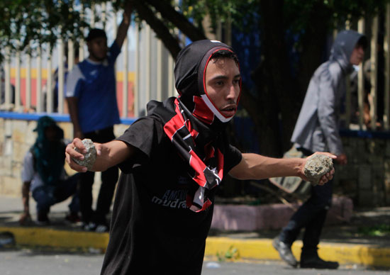 طالب فى يده الحجارة خلال الاشتباك مع قوات الأمن