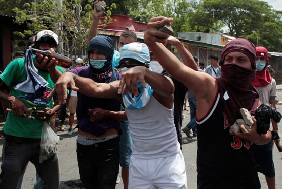 المتظاهرين يحملون الحجارة للاشتباك مع قوات الأمن