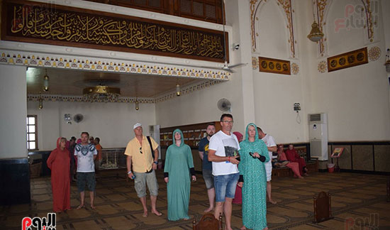 السياح يرتدون الإسدال قبل دخول المسجد