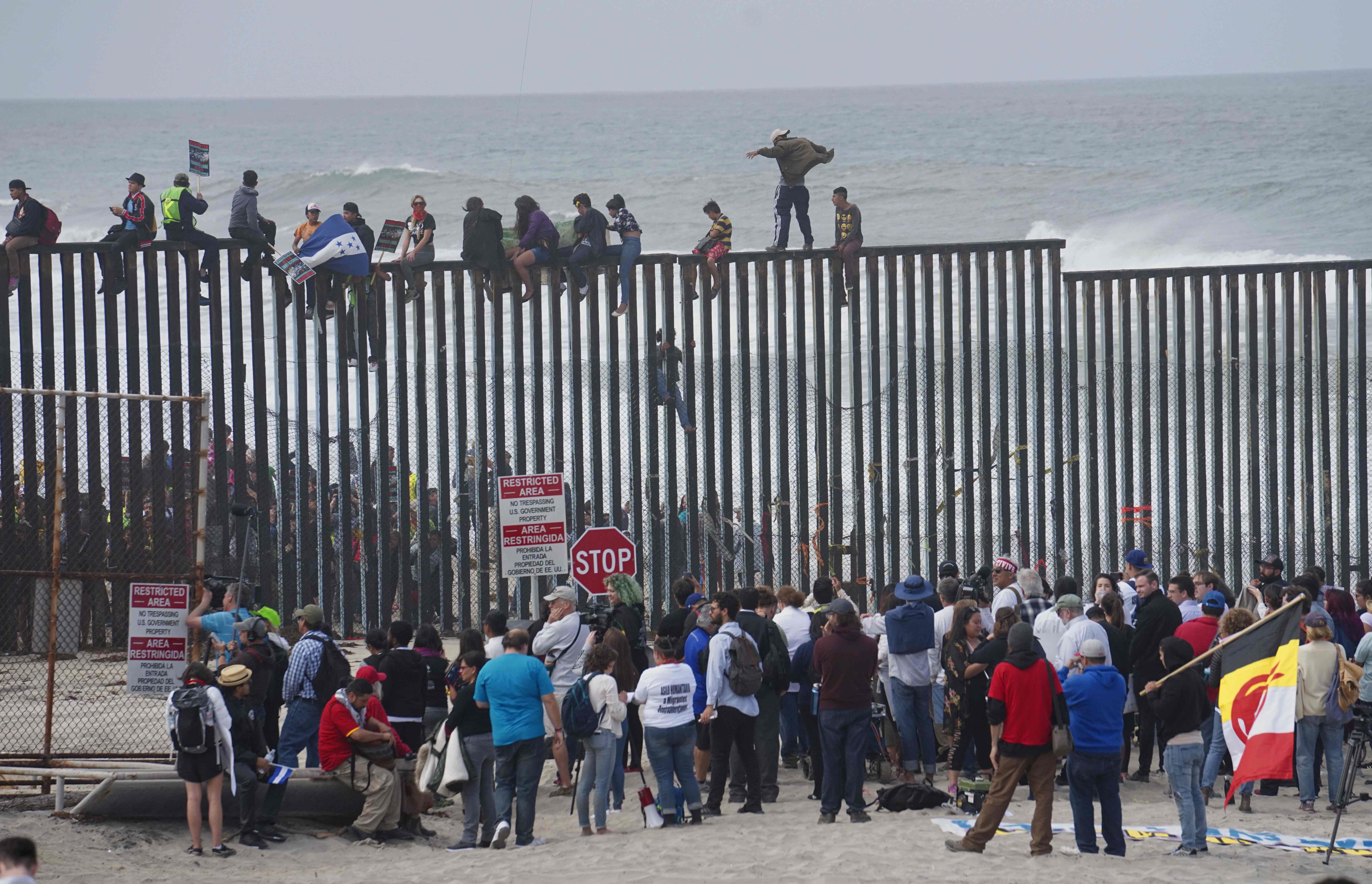 حشود المهاجرين فوق الجدار الحدودى