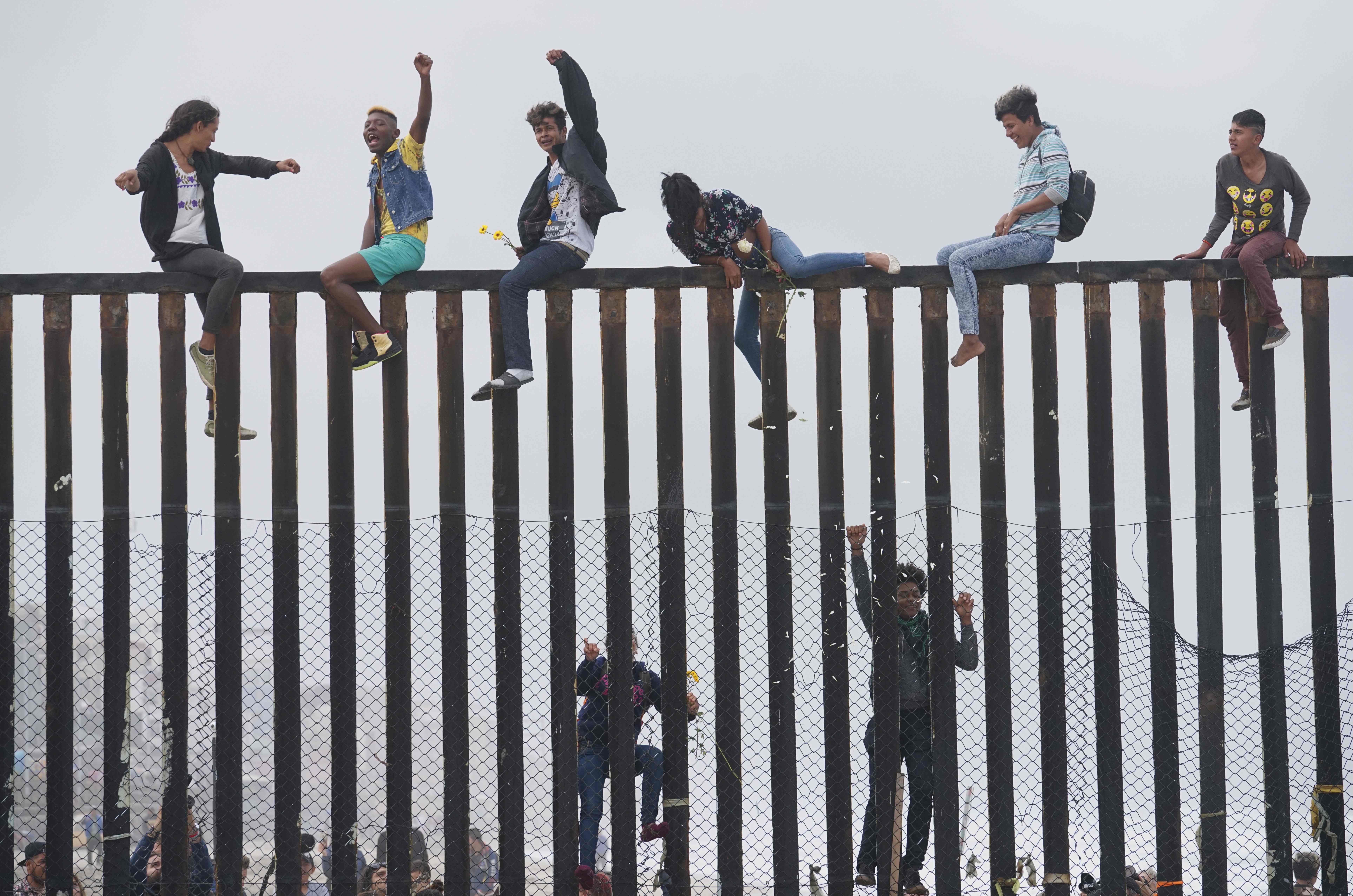 مهاجرون يتحدون ترامب ويقفزون فوق الجدار الحدودى