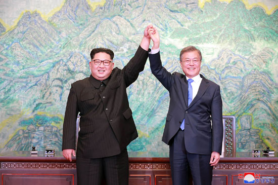 زعيما الكوريتين يرفعان أيديهما متشابكتان دلالة على الوحدة