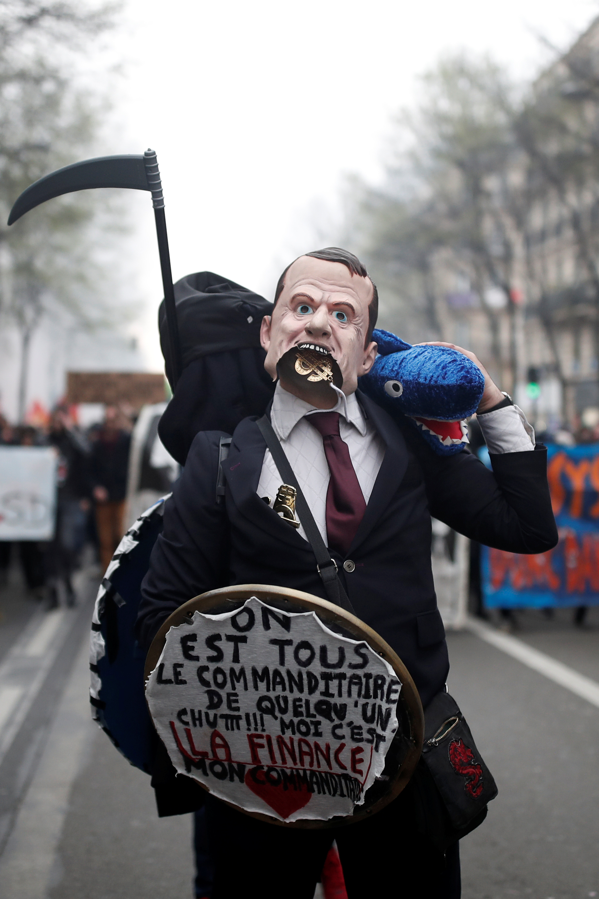 متظاهر يرتدى قناع لوجه الرئيس الفرنسى