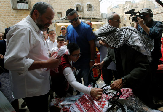 تاجر فلسطينى يبيع بضاعته قبل ضغوط قوات الاحتلال