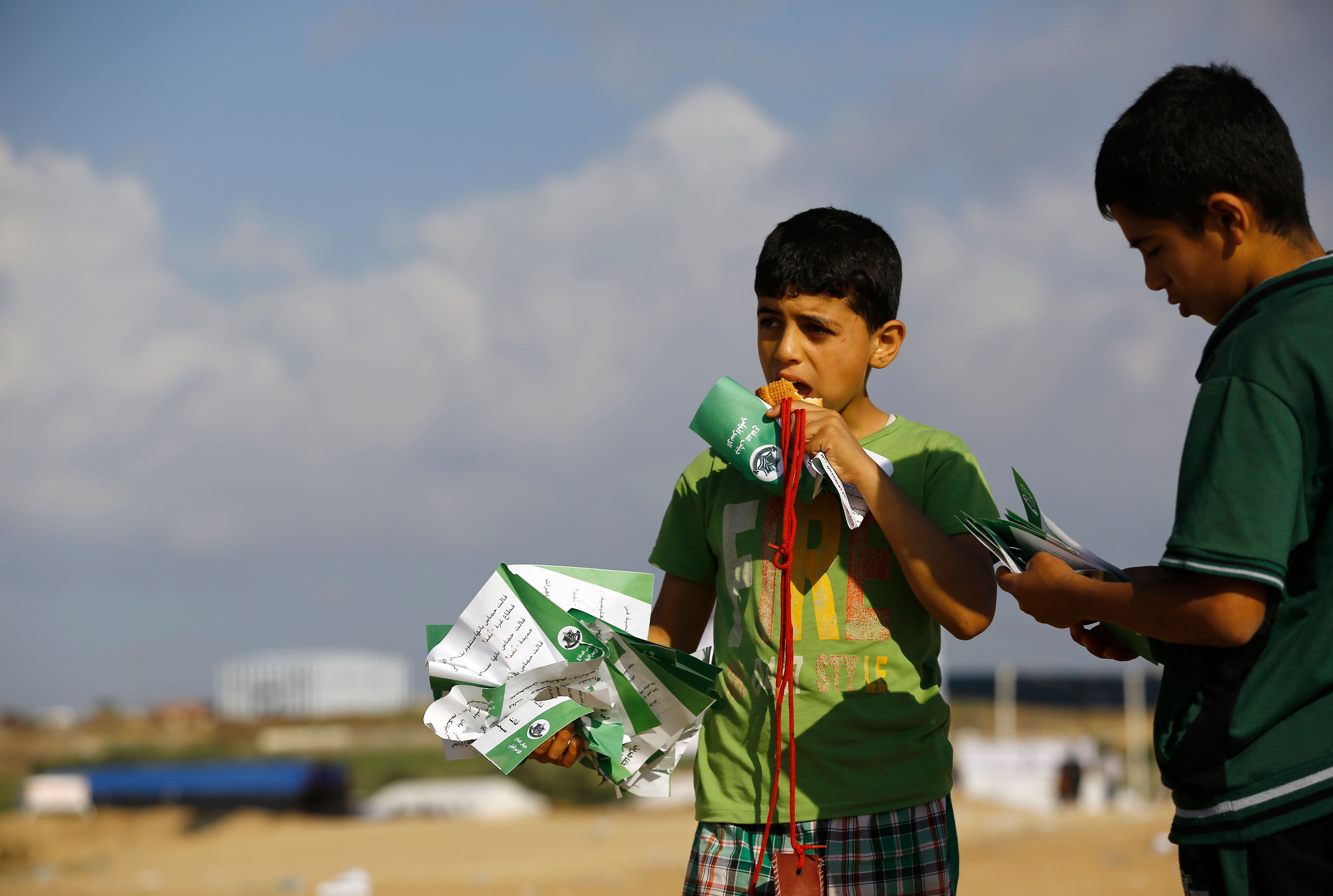 طفل فلسطينى يحمل منشورات التحذير الإسرائيلية
