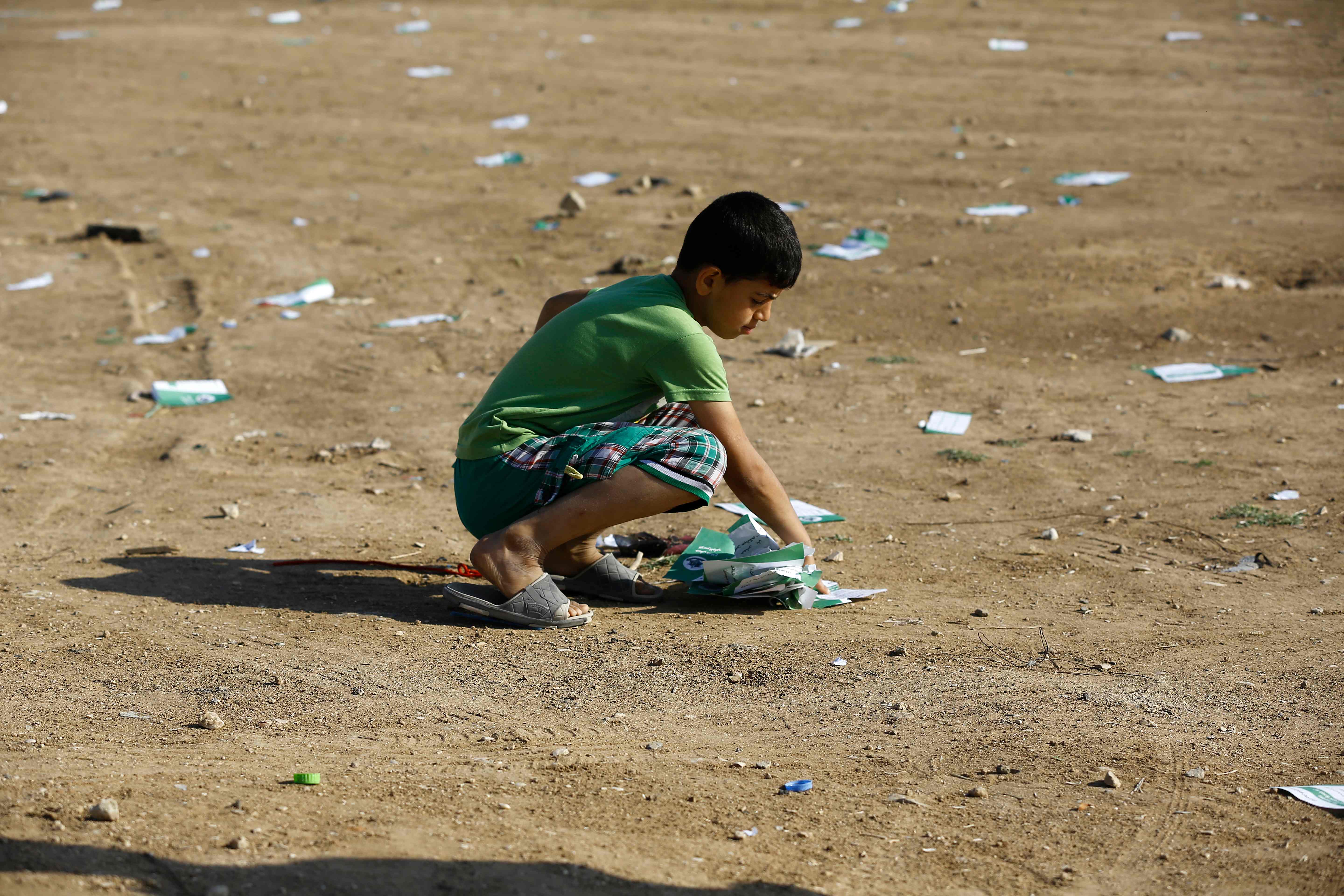 طفل فلسطينى يجمع منشورات الاحتلال التحذيرية