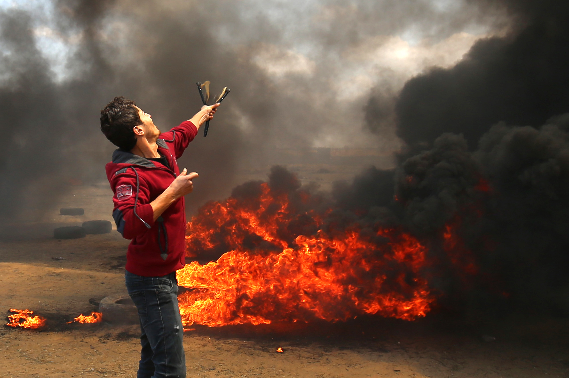 شاب فلسطينى يستخدم نبلته فى مواجهة رصاص الاحتلال