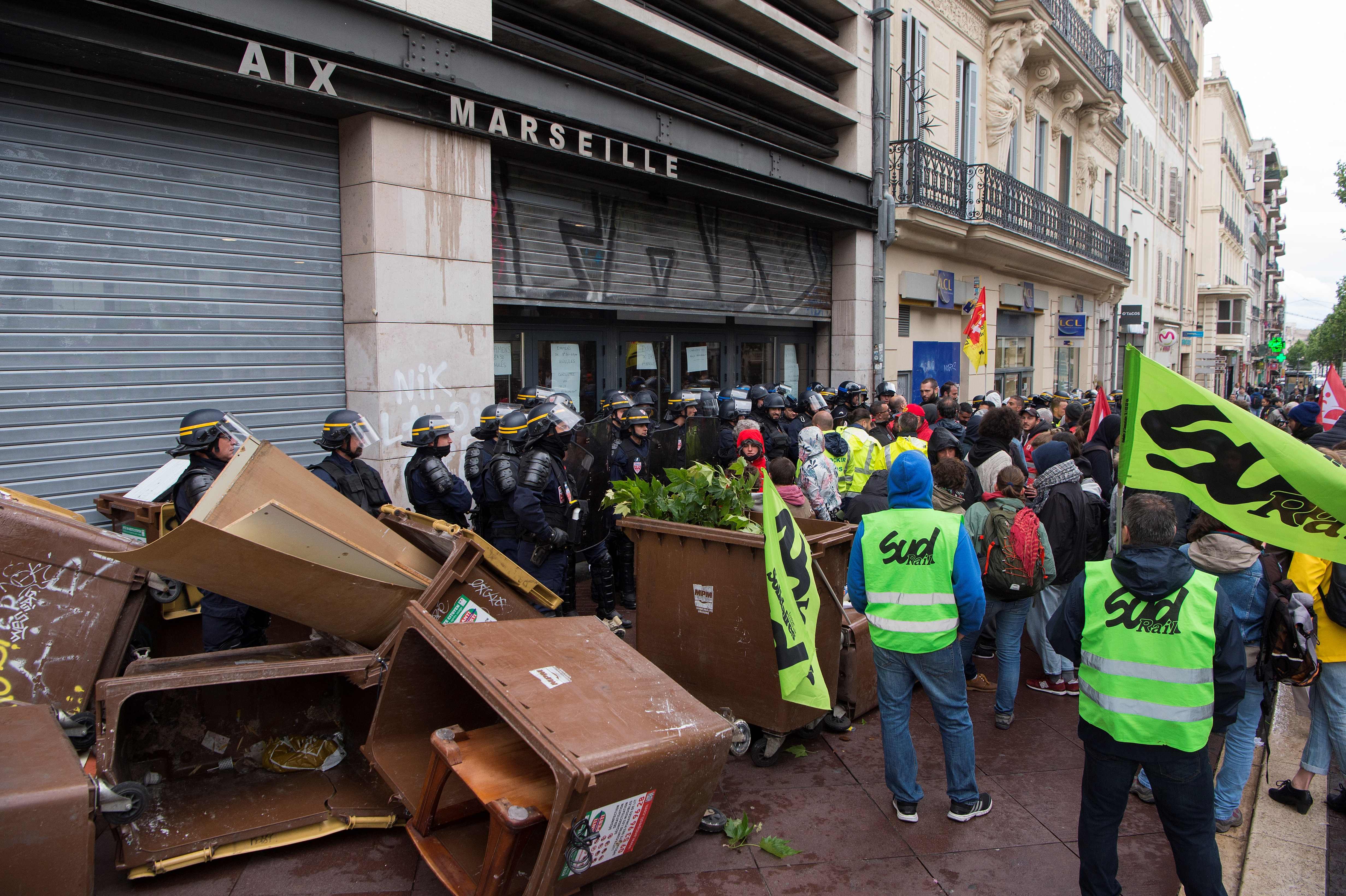 طلاب محتجين يقفون أمام باب جامعة فرنسية مغلقة