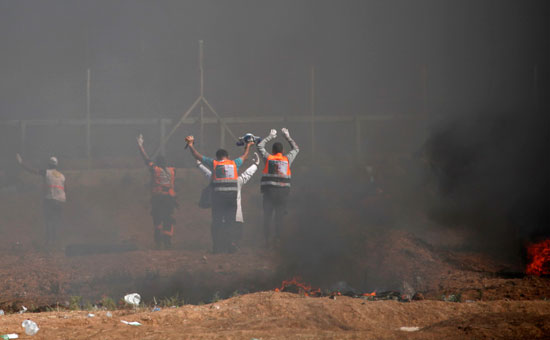 مسعفون فلسطينيون ينقلون المصابين من منطقة الاشتباكات بغزة