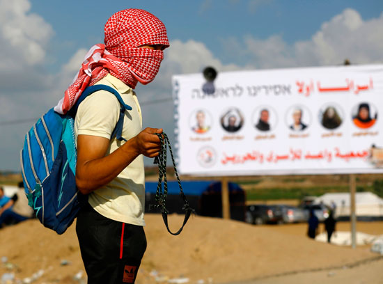 شاب فلسطينى يستعد لمواجهة قوات الاحتلال فى غزة