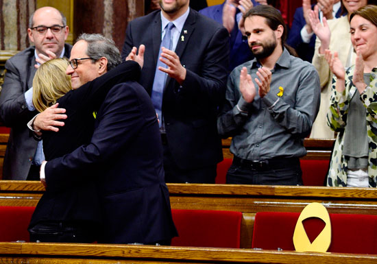 رئيس إقليم كتالونيا الجديد يحتضن زعيمه حزب بالبرلمان