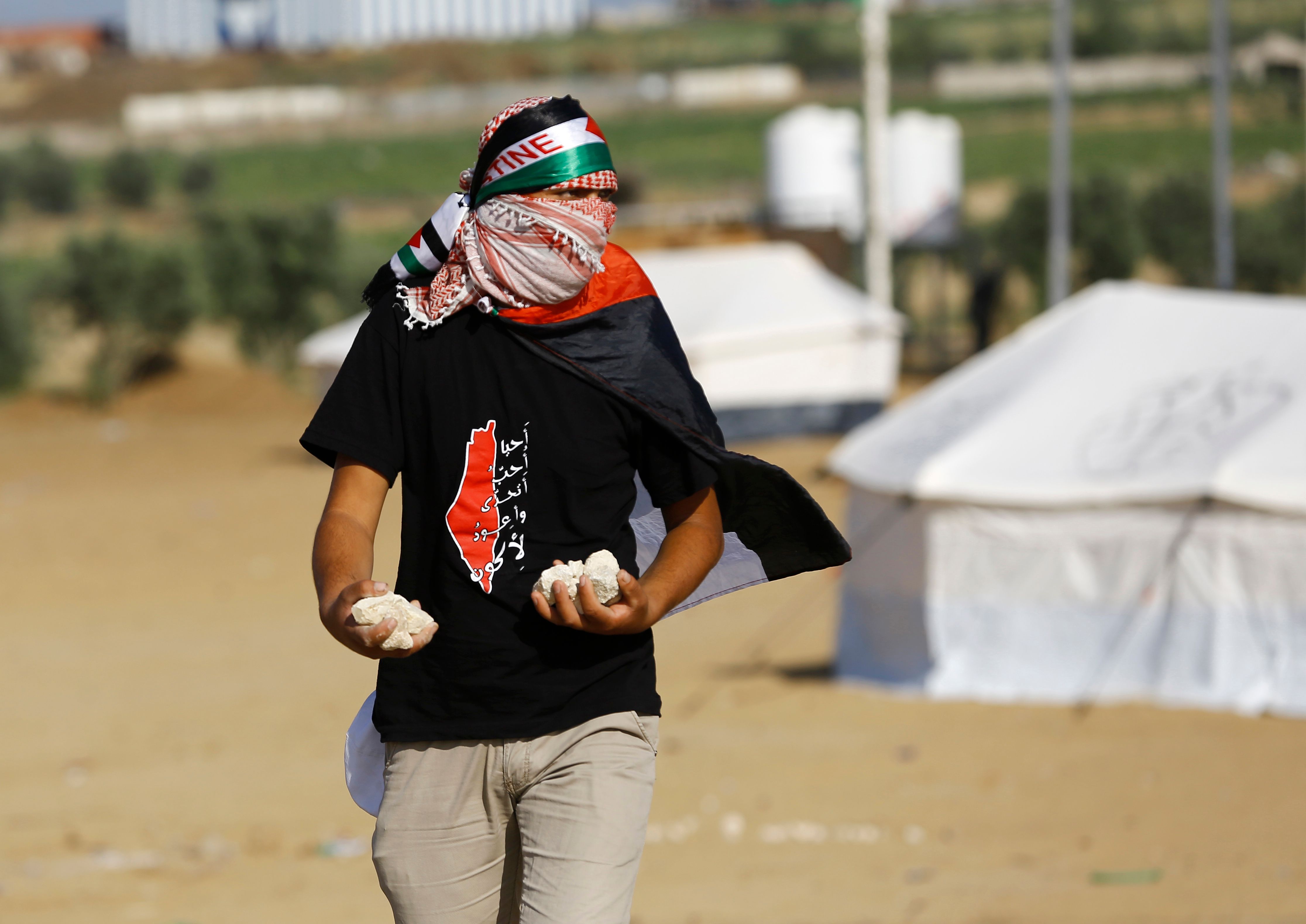 شاب فلسطينى يعد الحجارة لمواجهة رصاص الاحتلال بغزة