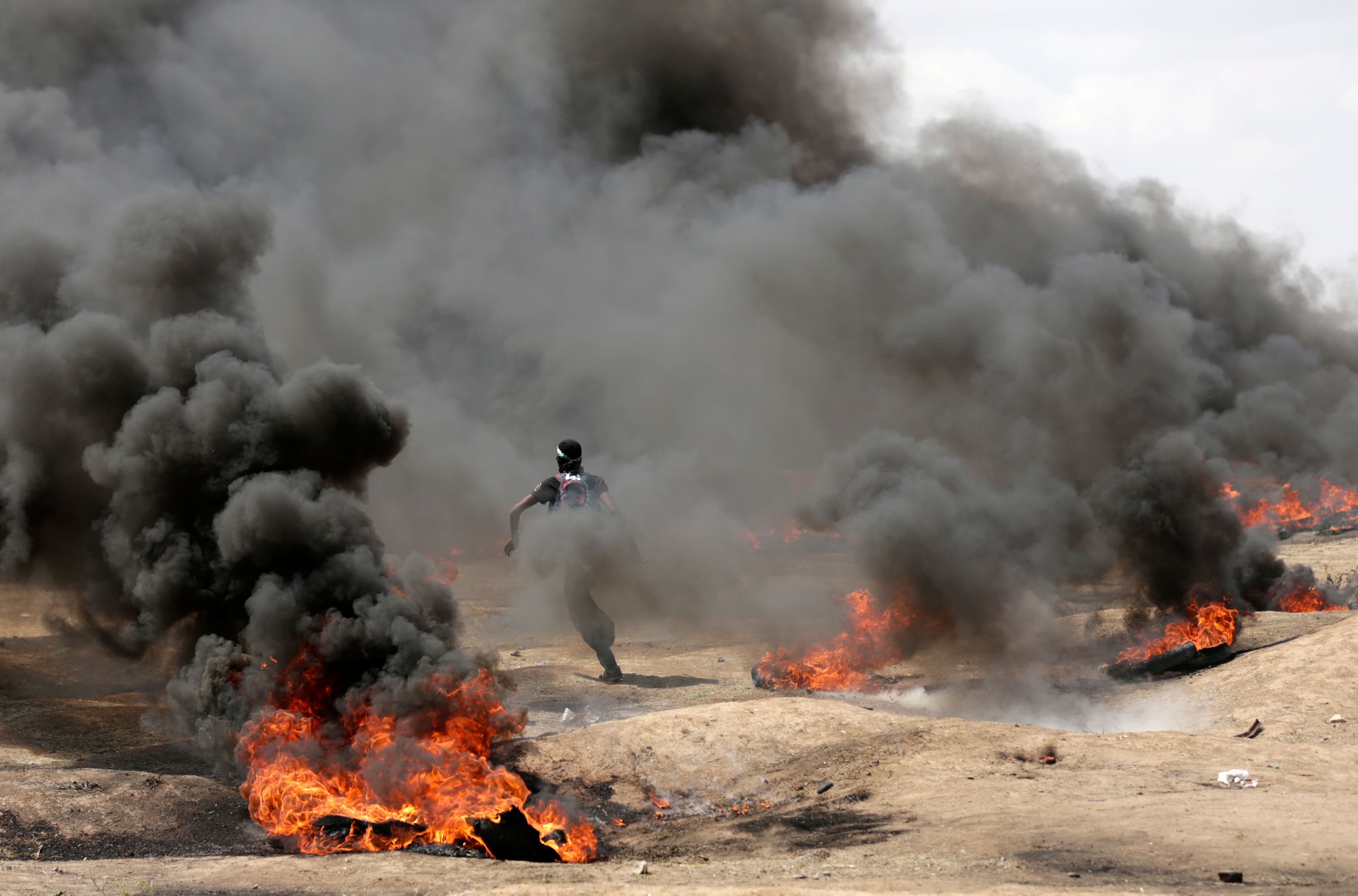 شاب فلسطينى يهرب من وسط الدخان الكثيف فى غزة