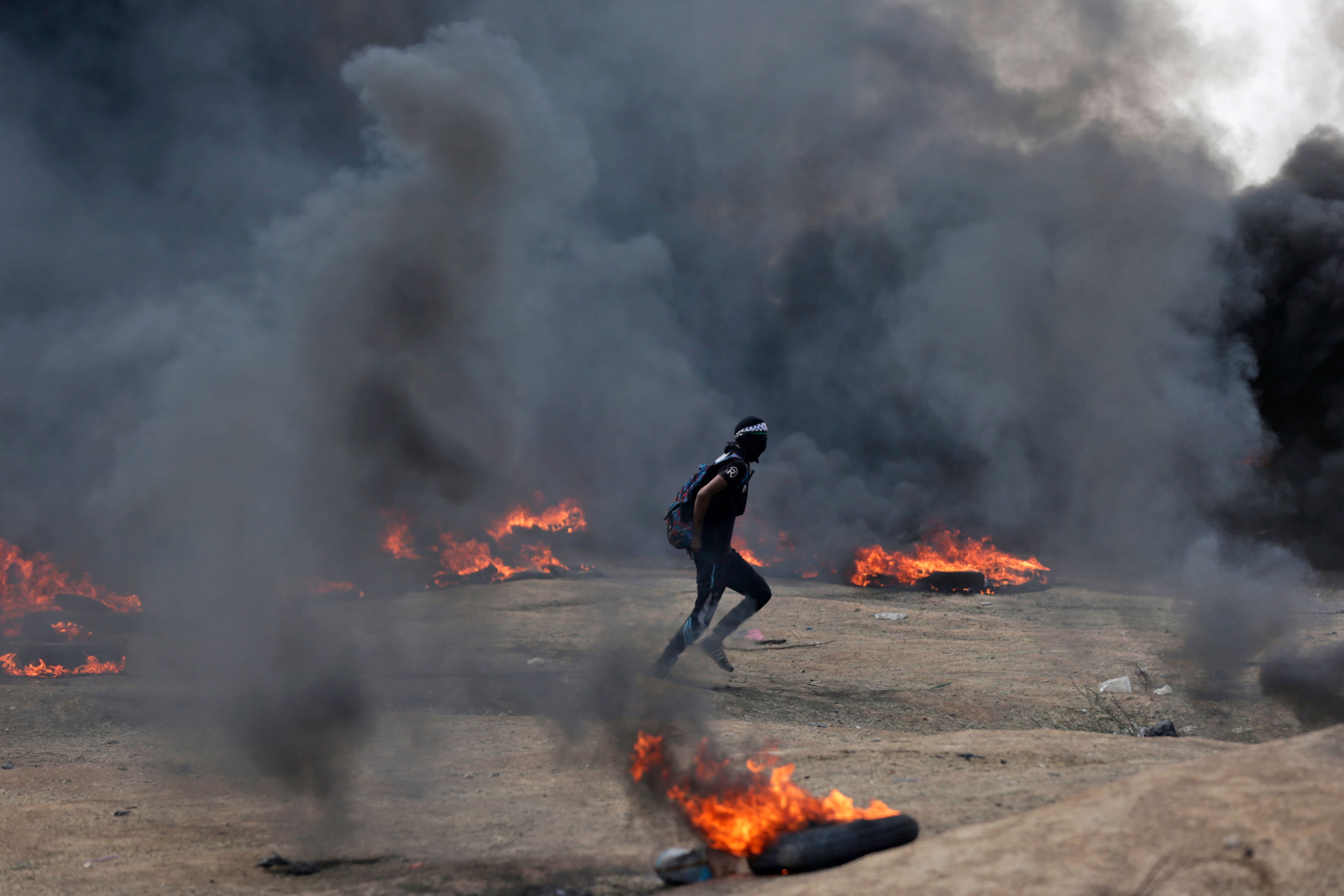 شاب فلسطينى يهرول وسط النيران على حدود غزة