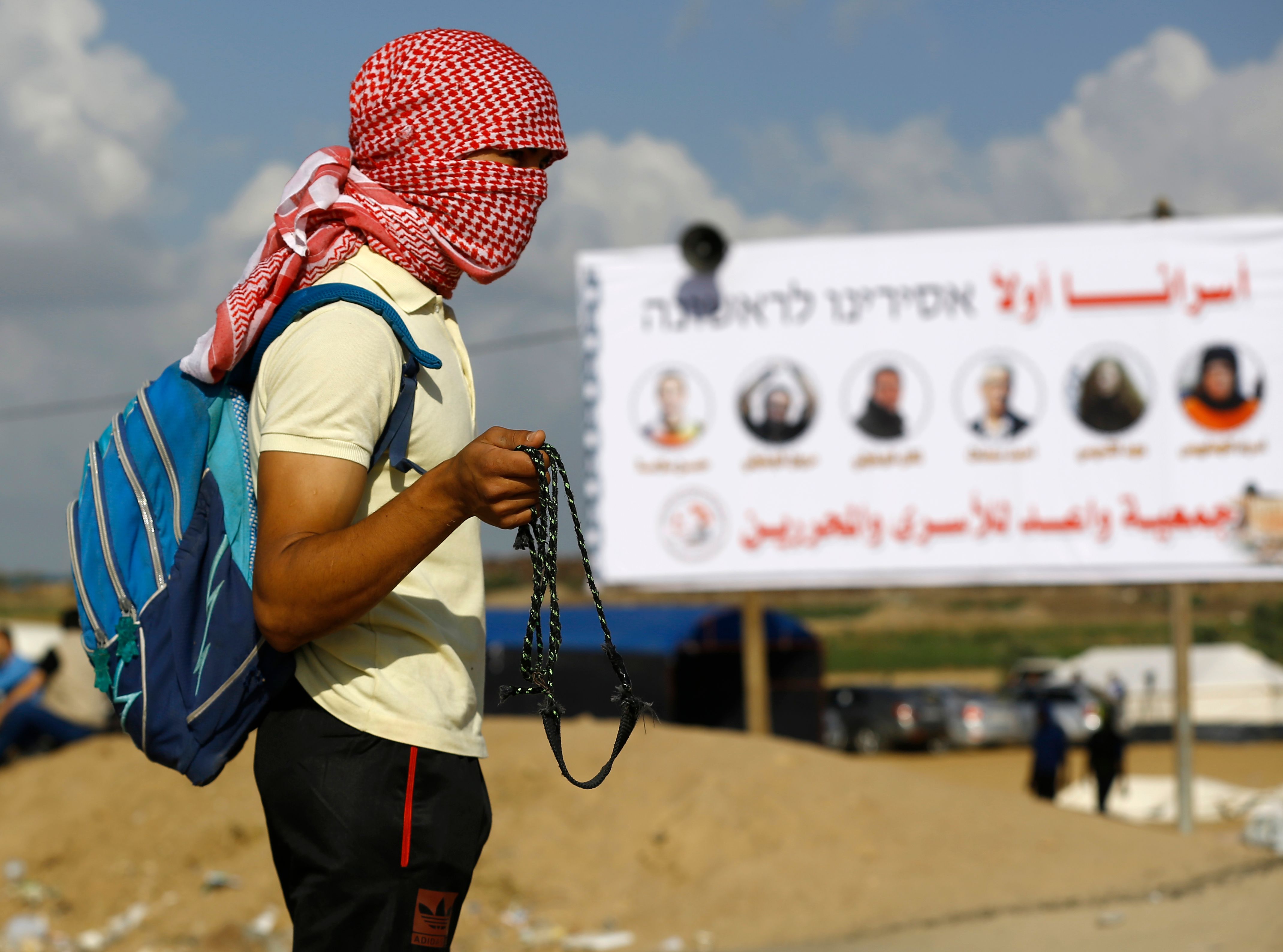 شاب فلسطينى يستعد لمواجهة قوات الاحتلال فى غزة