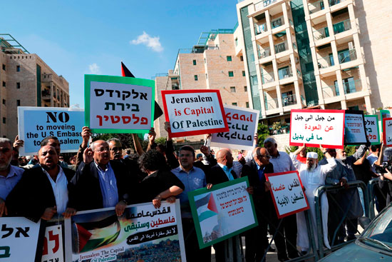 فلسطينيون يرفعون لافتات منددة بنقل السفارة الأمريكية