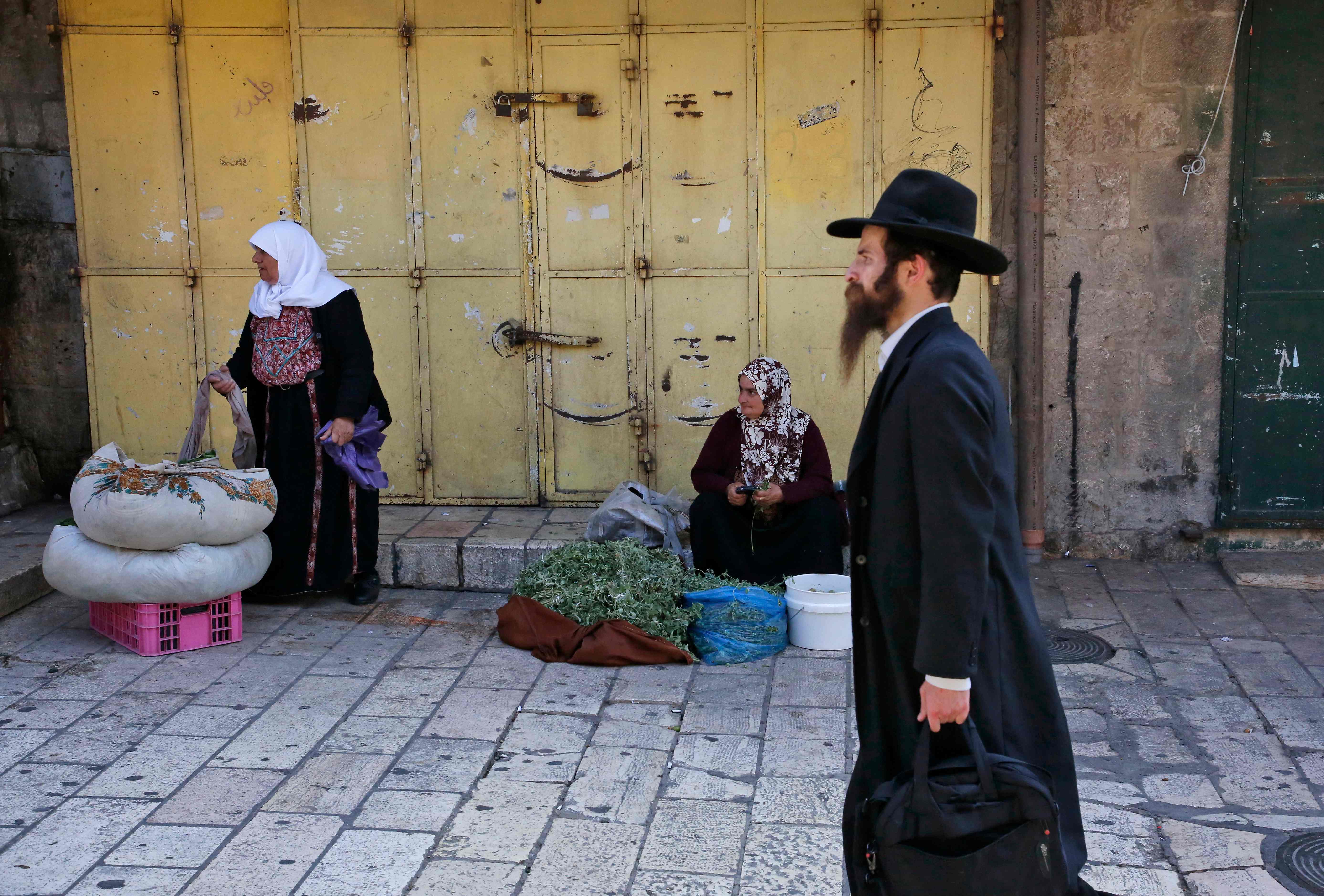 رجل يهودى يمر أمام بائعة فلسطينية خلال الإضراب العام