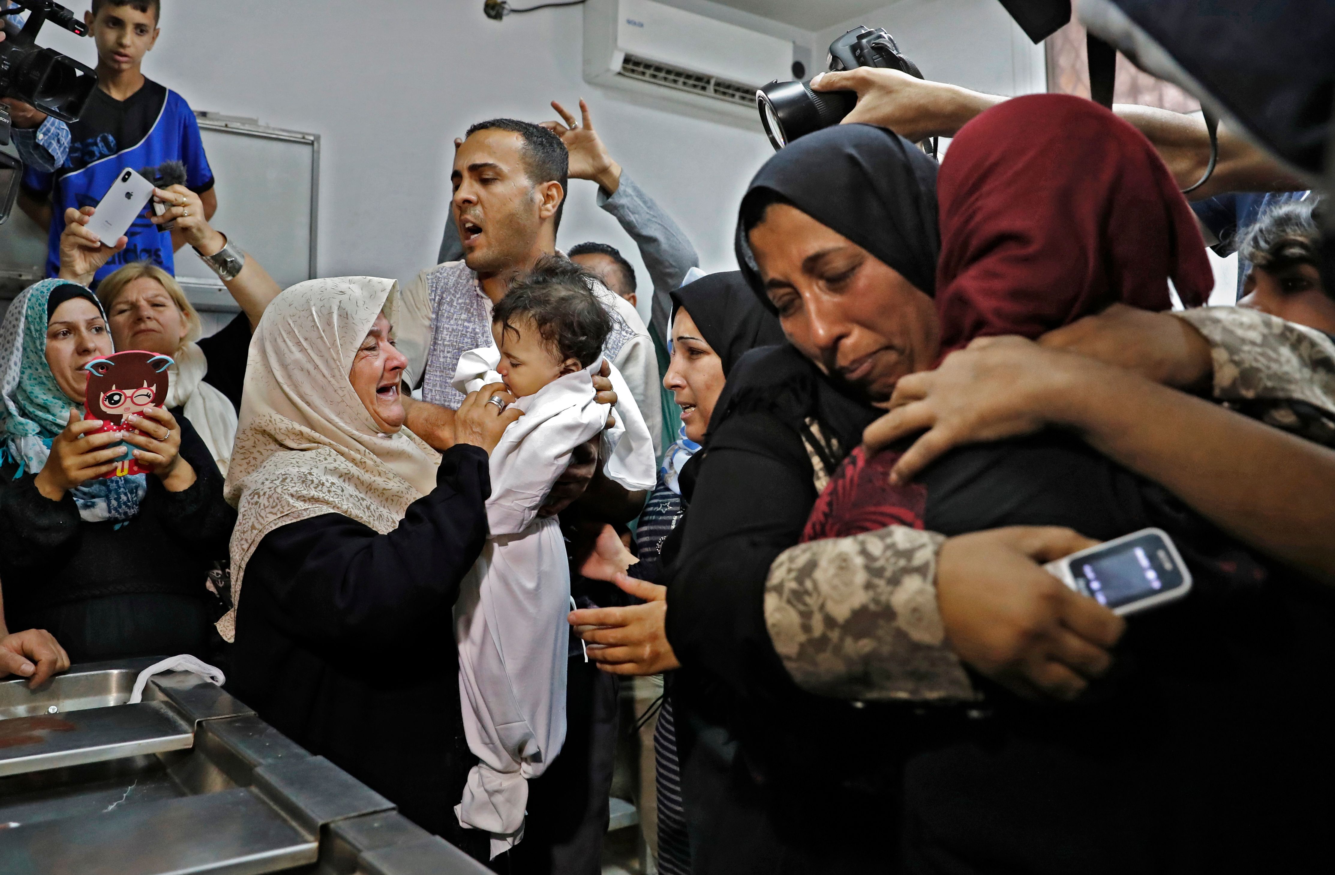 سيدة فلسطينية تحمل جثمان طفلة شهيدة