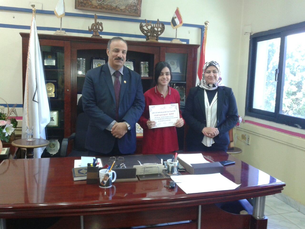 2- وكيل الوزارة ووكيل المديرية مع احدى الطالبات المكرمات 2- وكيل الوزارة ووكيل المديرية مع احدى الطالبات المكرمات