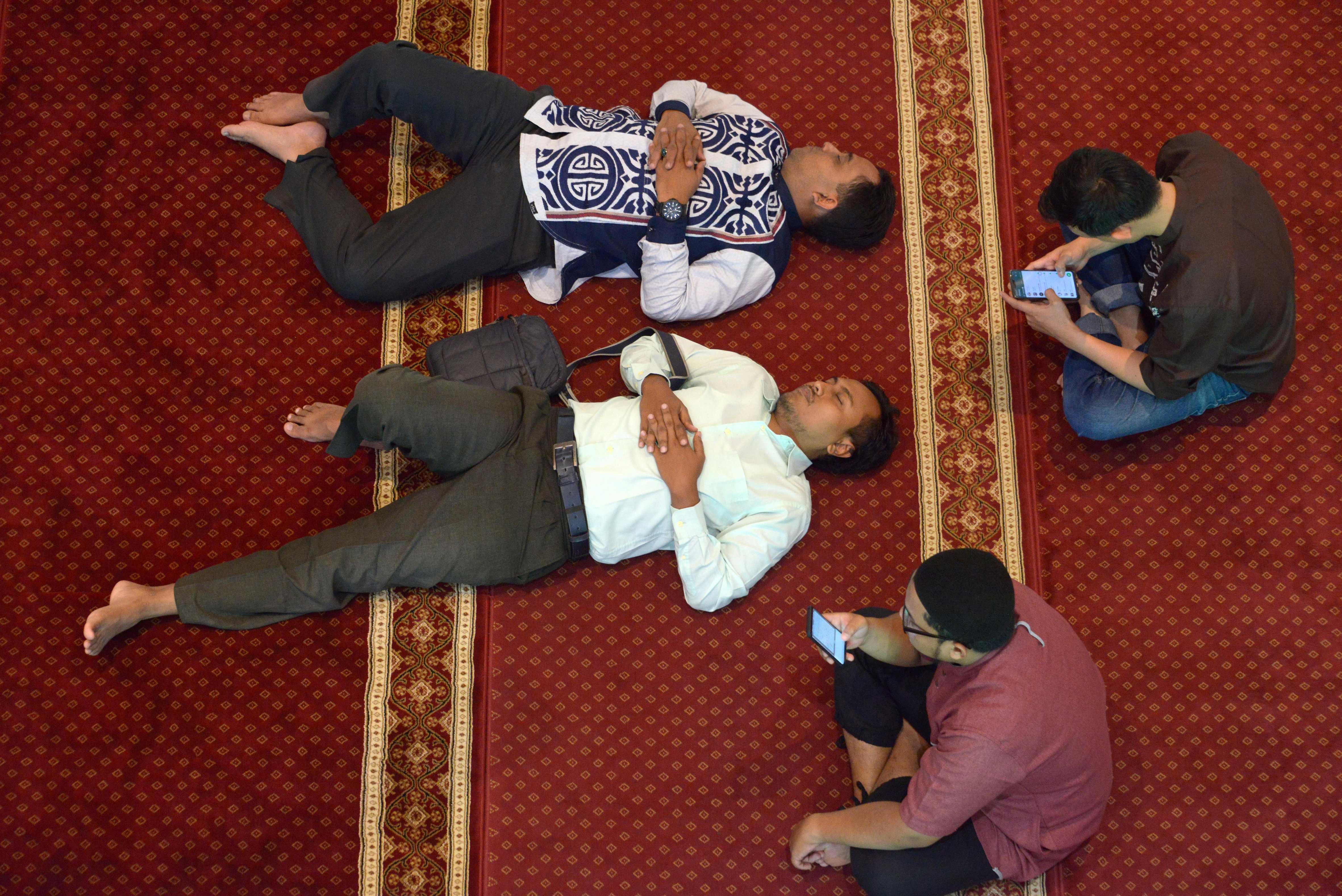 بعض الأشخاص يسترحون فى المسجد بعد قراءة القرآن
