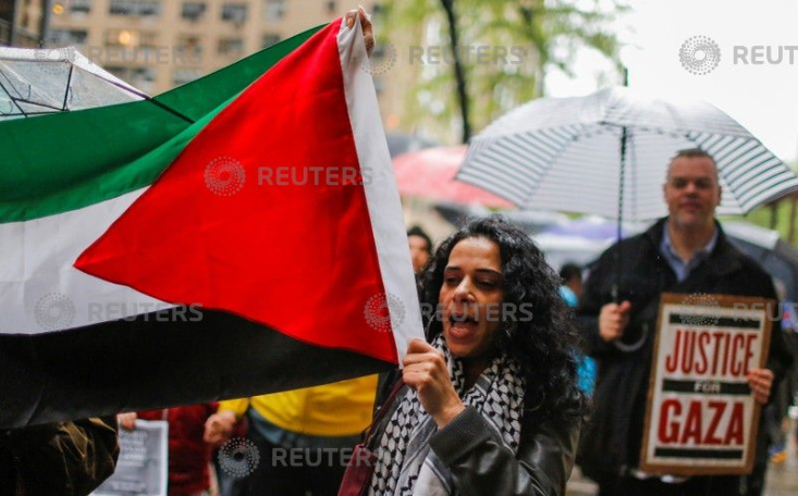 سيدة ترفع علم فلسطين خلال المظاهرات
