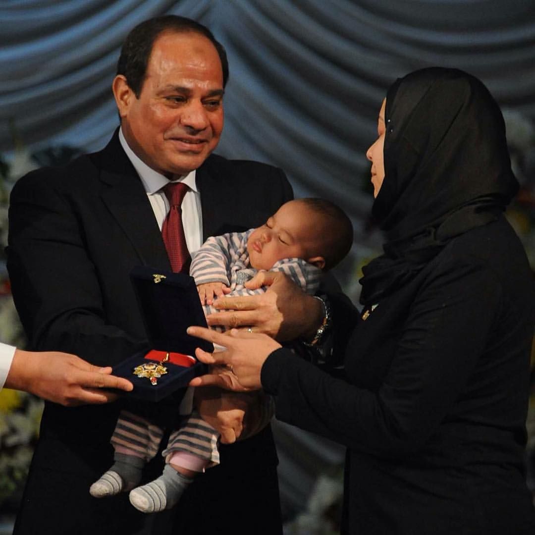 الرئيس عبد الفتاح السيسي يحمل ابن الشهيد أحمد جمال