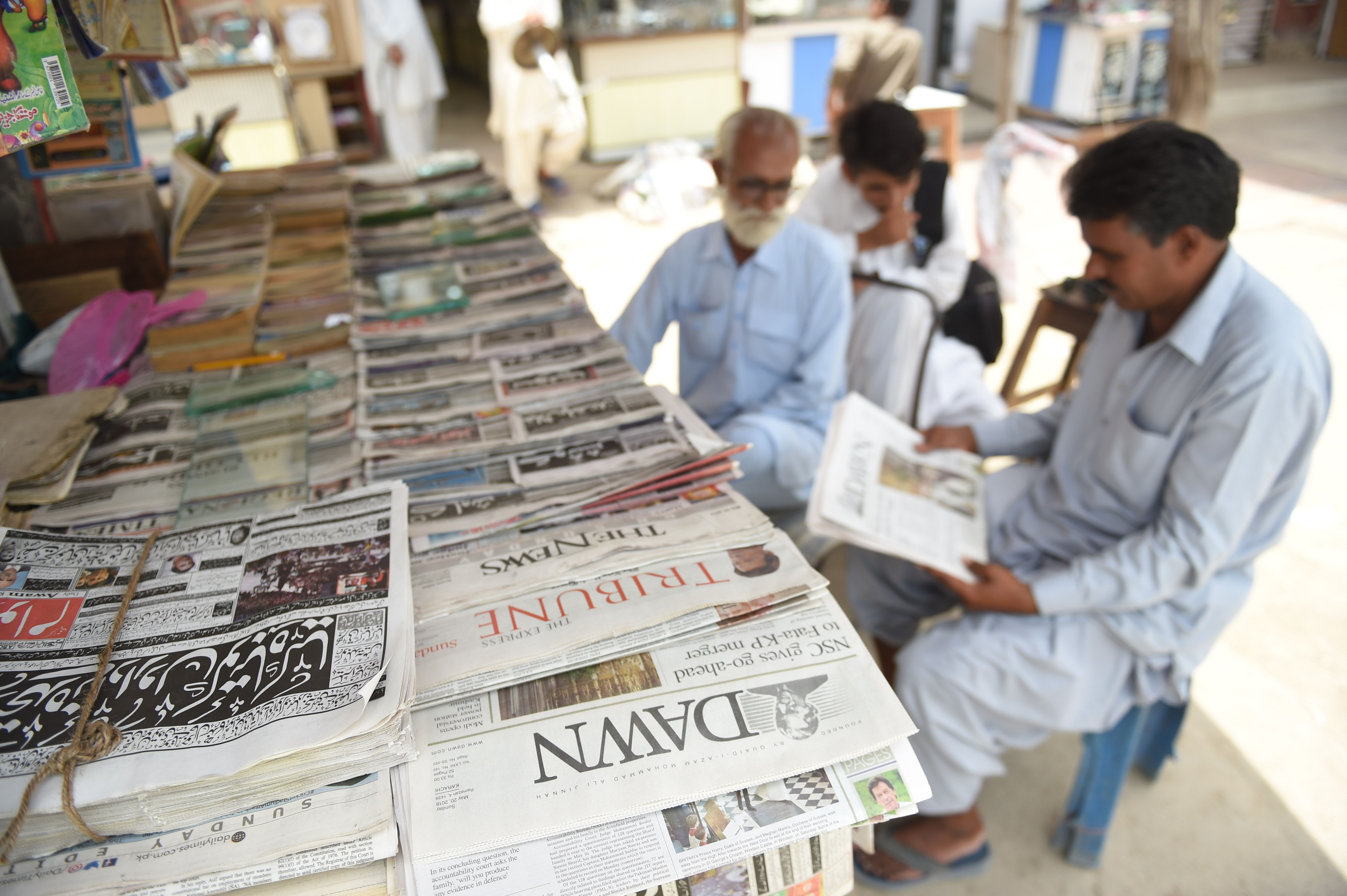 مواطن باكستانى يقرأ جريدة تواجه عرقلة فى التسويق