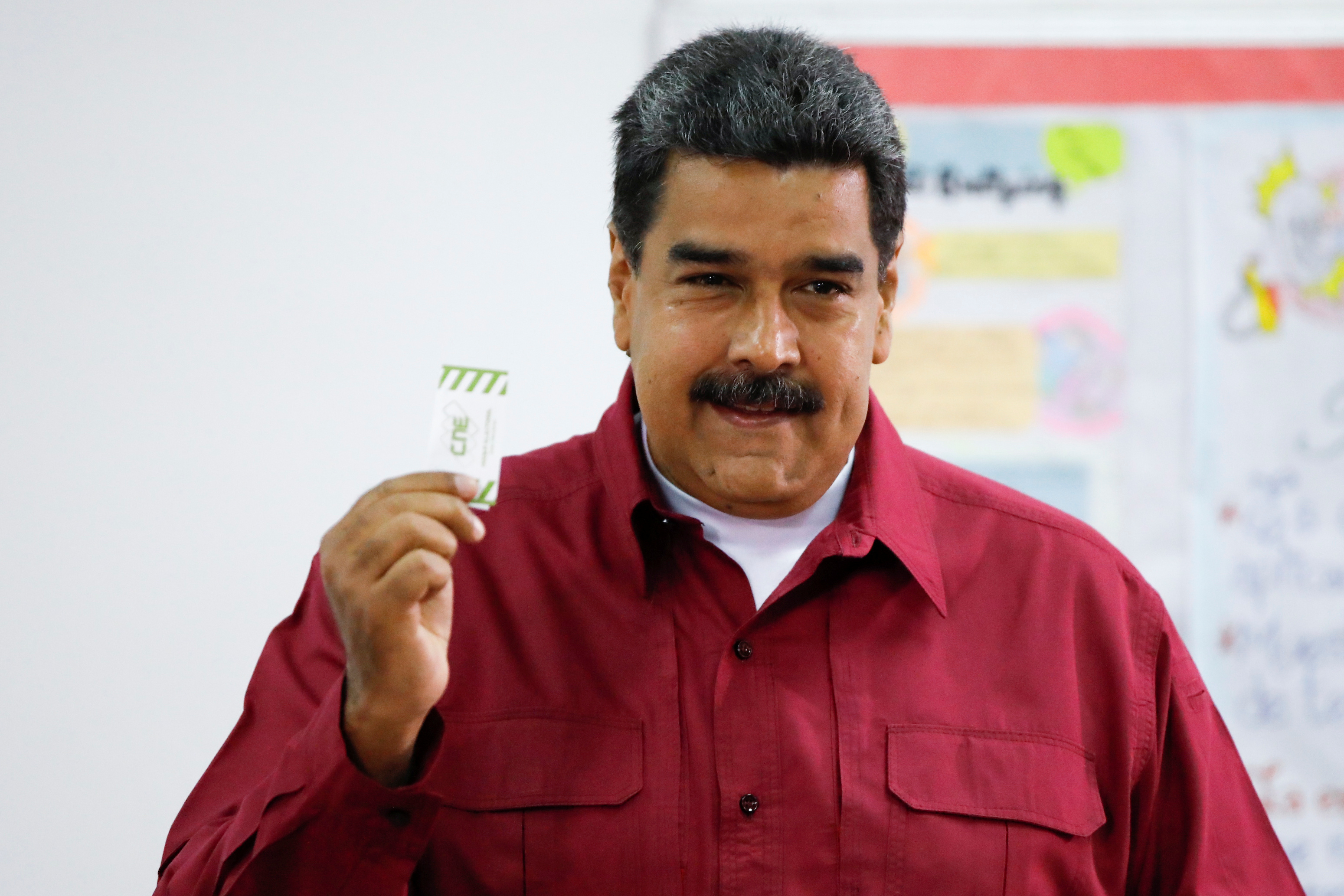 نيكولاس مادورو يرفع ورقة اقتراع انتخابات الرئاسة