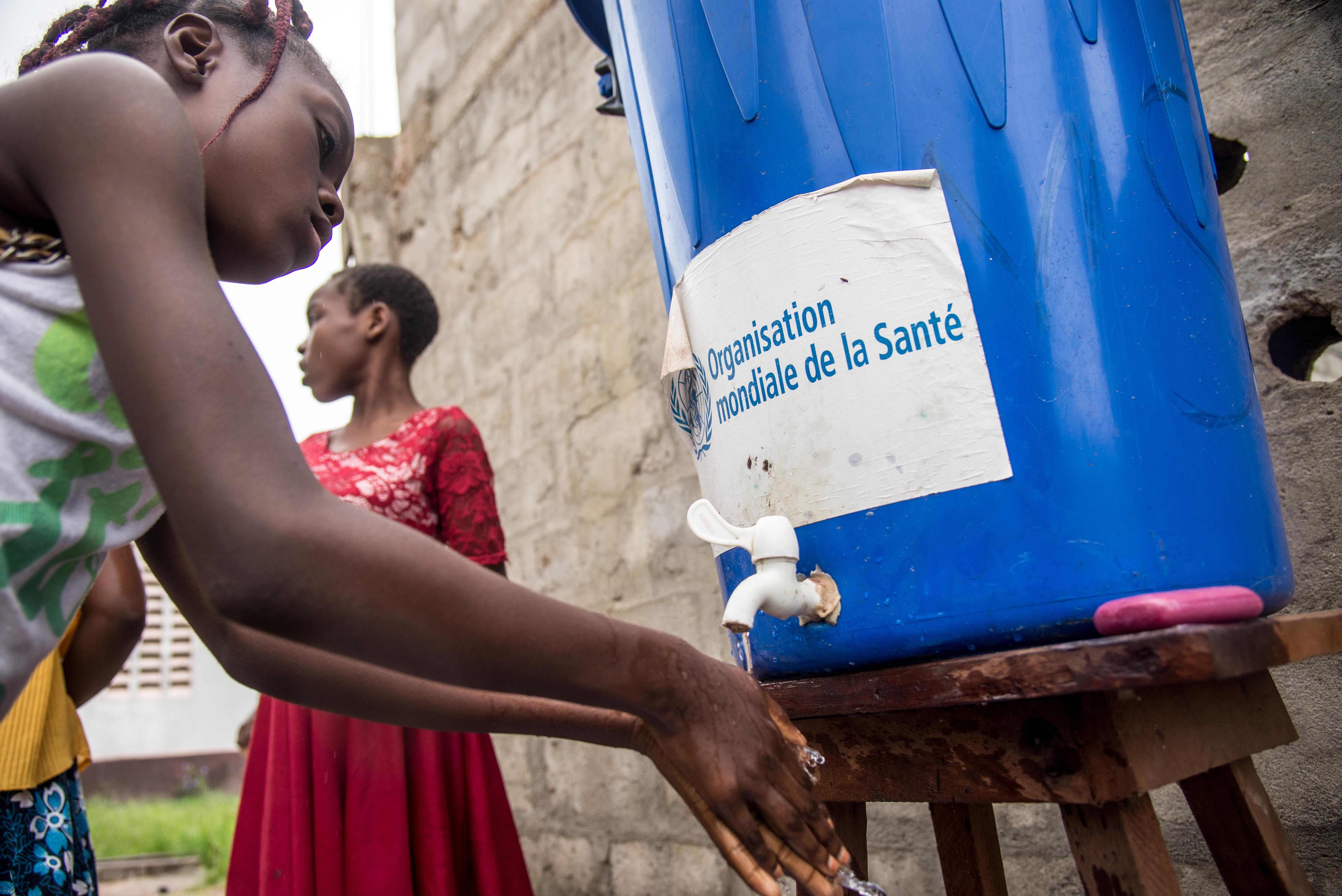 فتاة تغسل يدها بماء خاص بمنظمة الصحة العالمية 