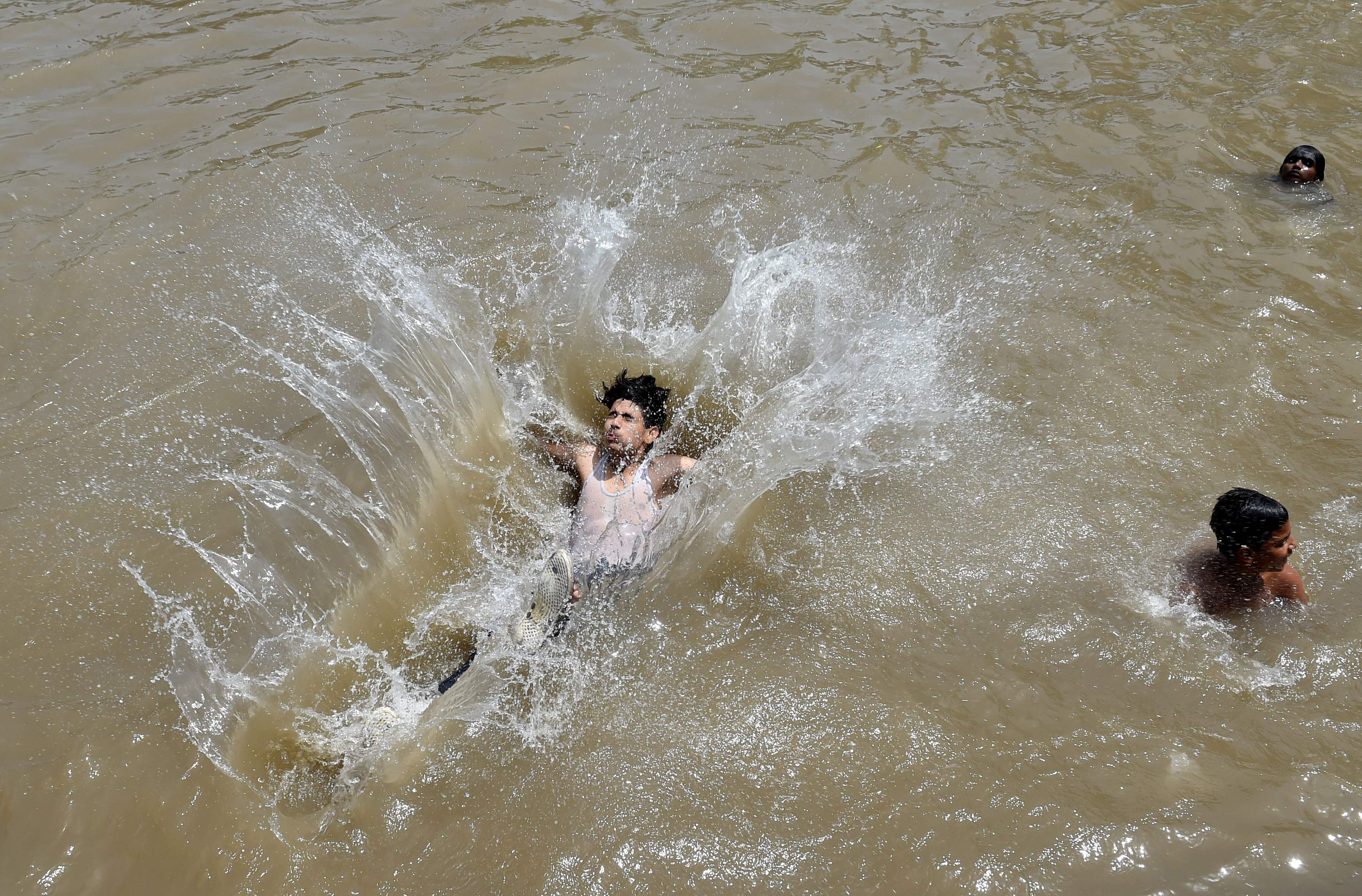 شاب باكستانى يستحم فى البحر هربًا من موجة الحر