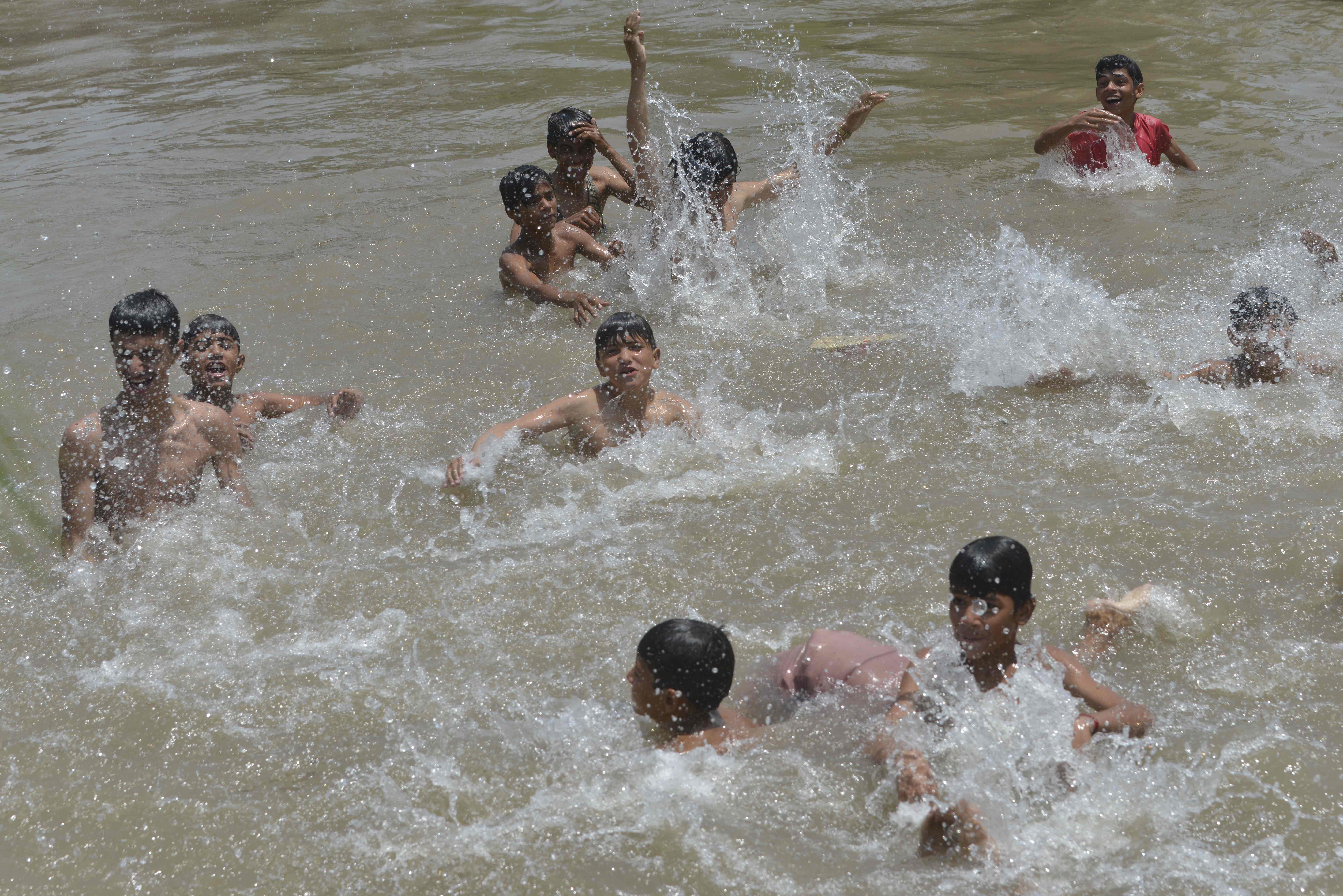 شباب باكستانيون يهربون إلى الشواطئ من الحر